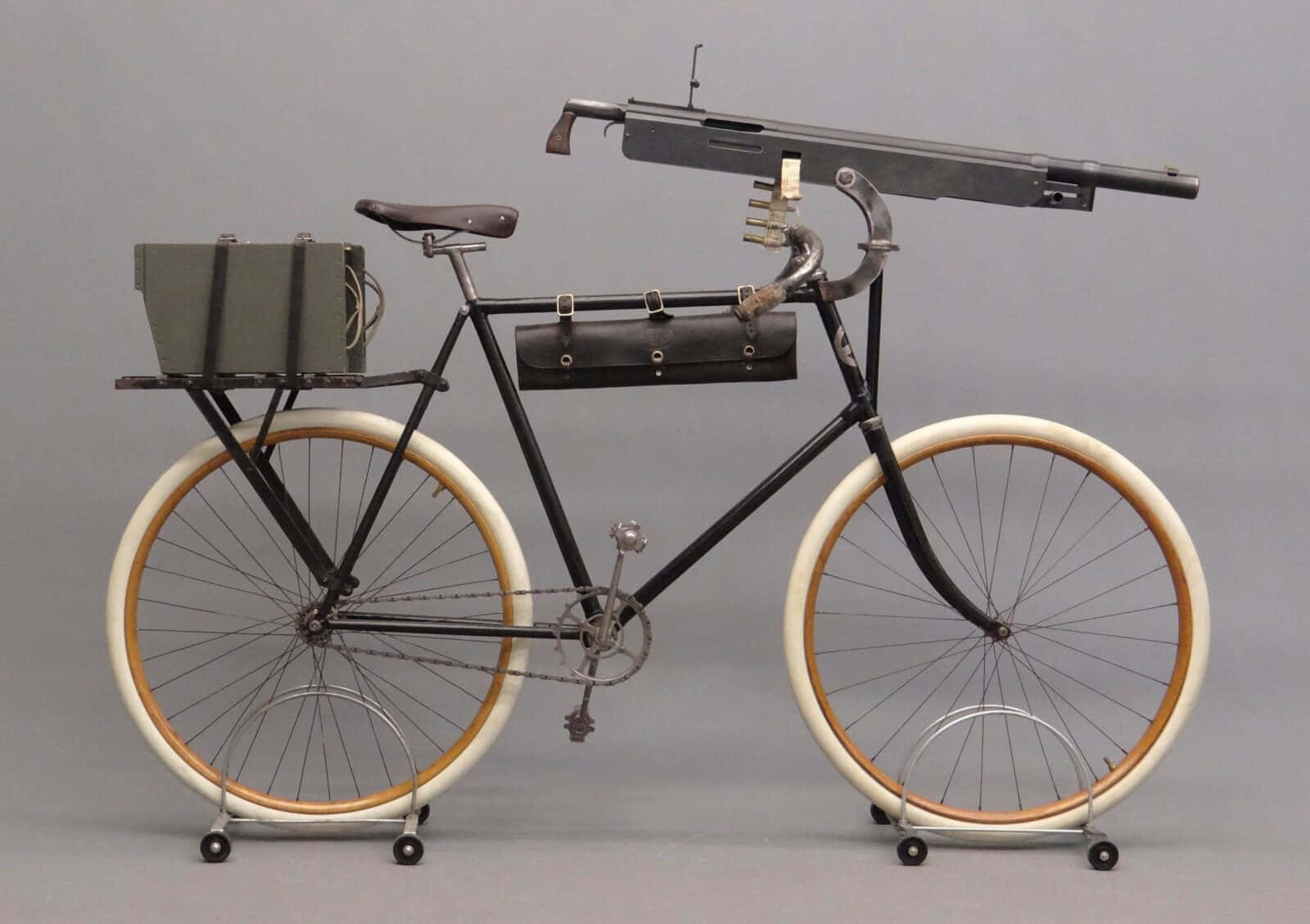 Bicycle 桌布 壁紙 — 復古自行車，配有安裝式機槍和皮革鞍袋，背景為中性灰色工作室。