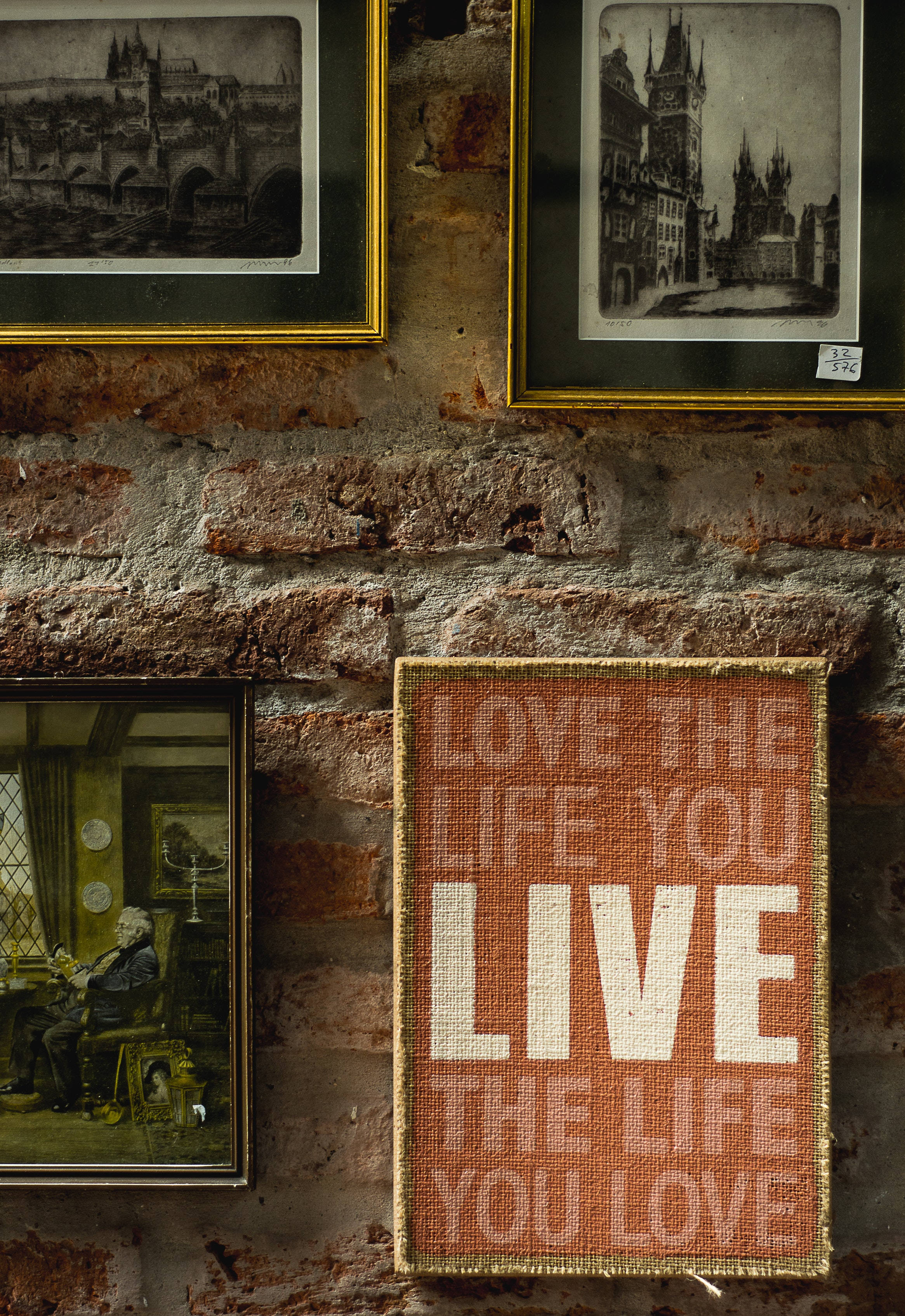 語錄 桌布 壁紙 — 復古裱框照片和一個編織的「love the life you live」標誌裝飾著質樸的裸露磚牆。