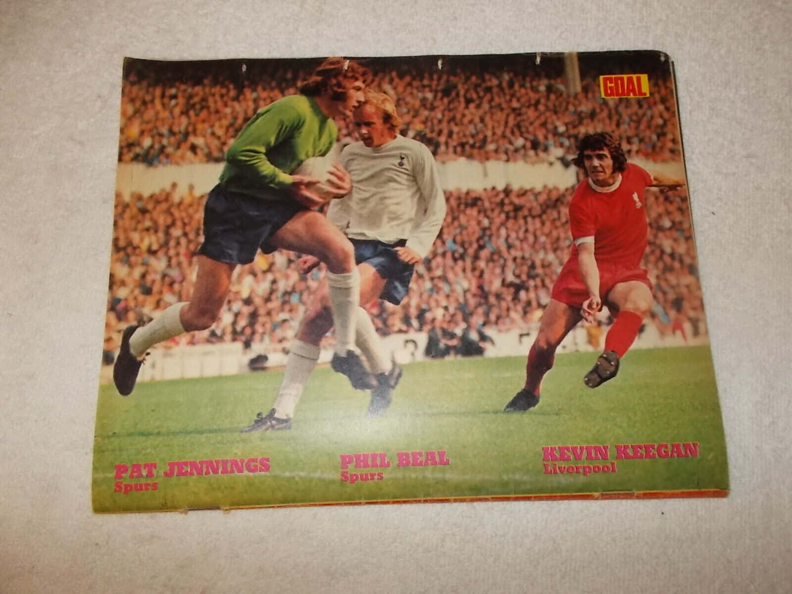 Magazine 桌布 壁紙 — 復古足球海報，展示 Pat Jennings、Phil Beal 和 Kevin Keegan 在擁擠的球場上比賽中的動作。