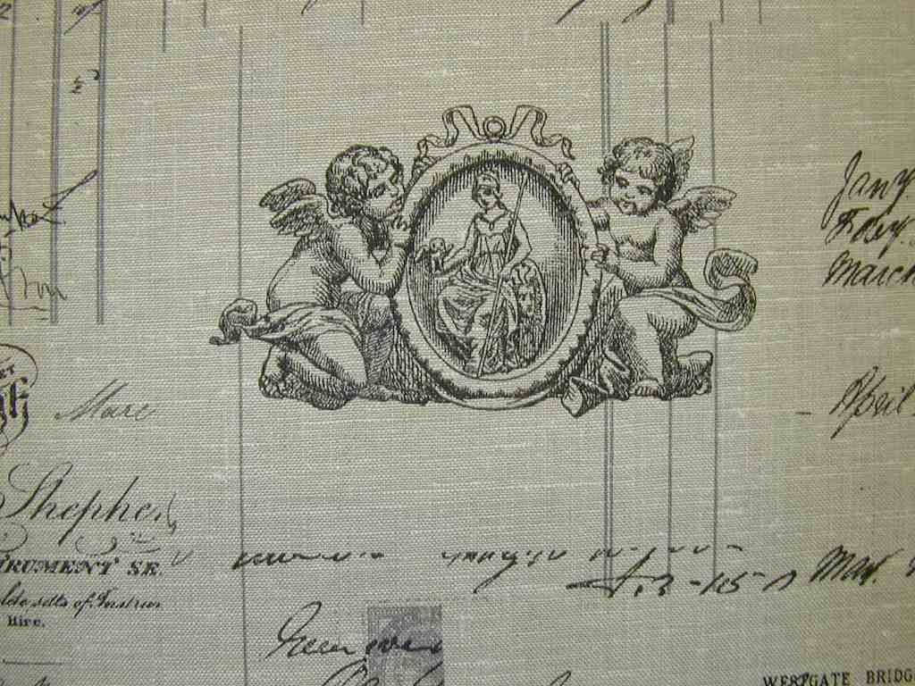 Old Paper 桌布 壁紙 — 復古雕刻徽章，兩個小天使在華麗橢圓框內簇擁著中央人物，位於帶有手寫字體的舊紙上。