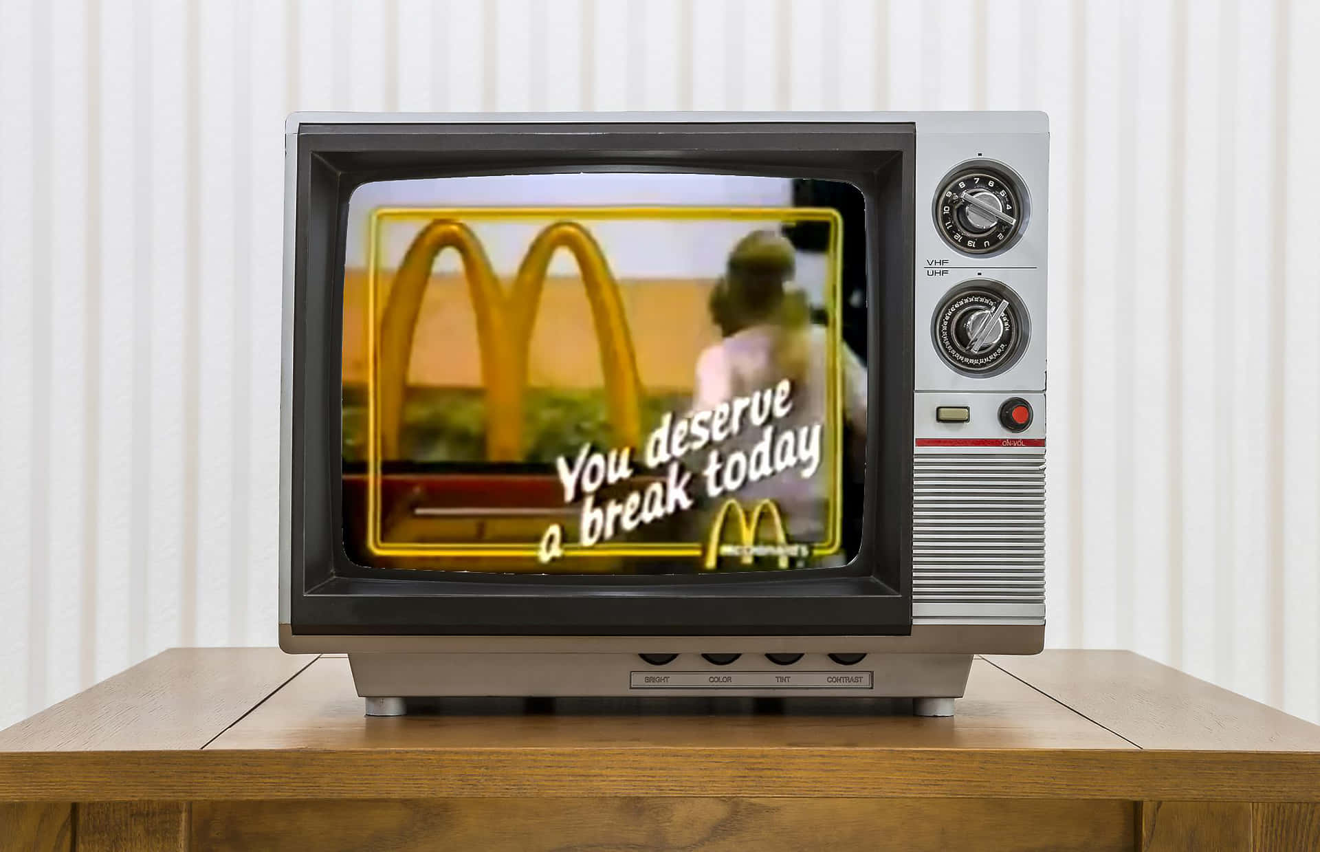 Mcdonalds 桌布 壁紙 — 復古電視顯示麥當勞廣告，金色拱門和文字「You deserve a break today」，背景溫暖。