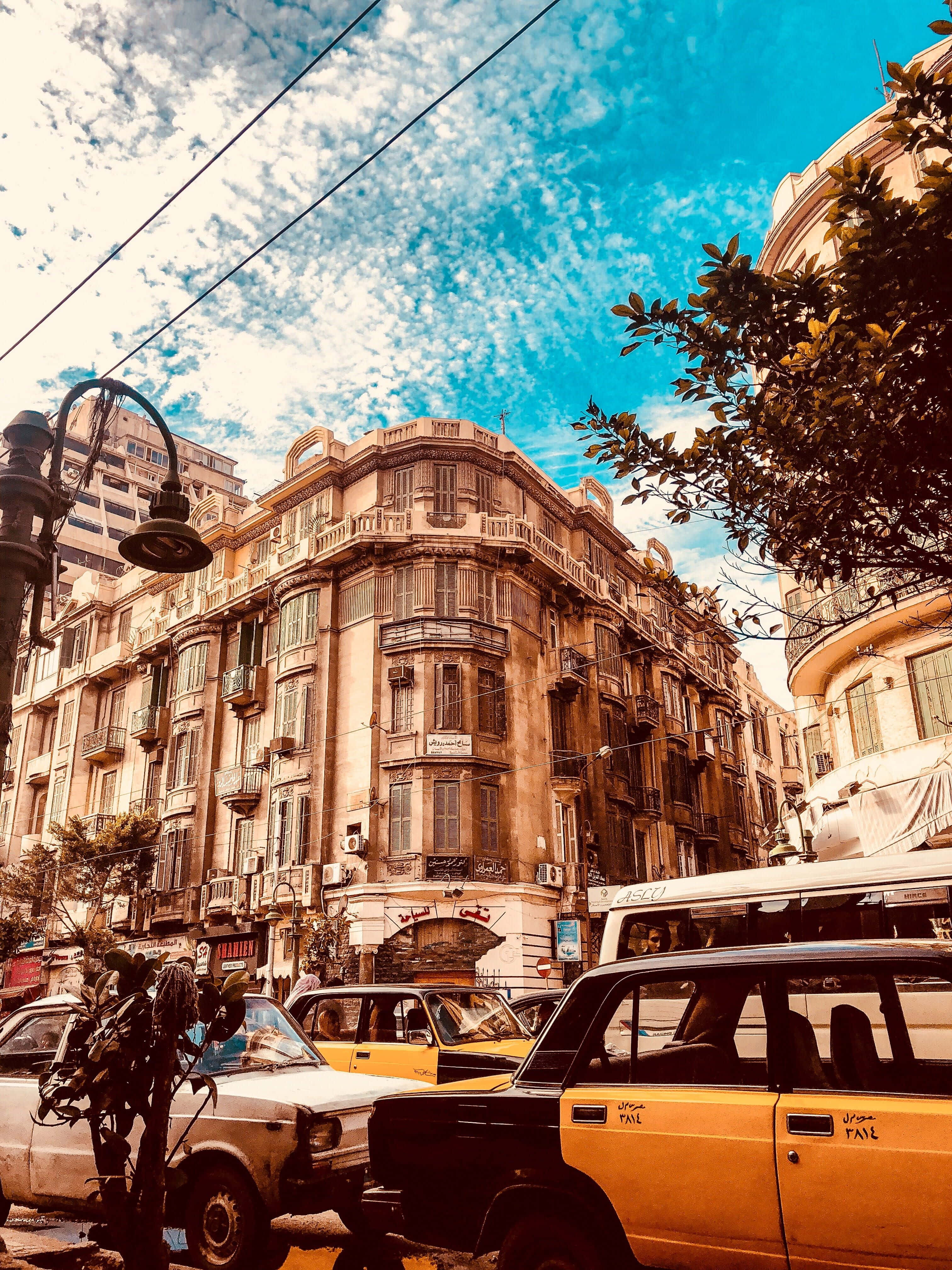 Alexandria 桌布 壁紙 — 復古黃色計程車排列在繁華的街道上，天空湛藍，點綴著縷縷白雲。