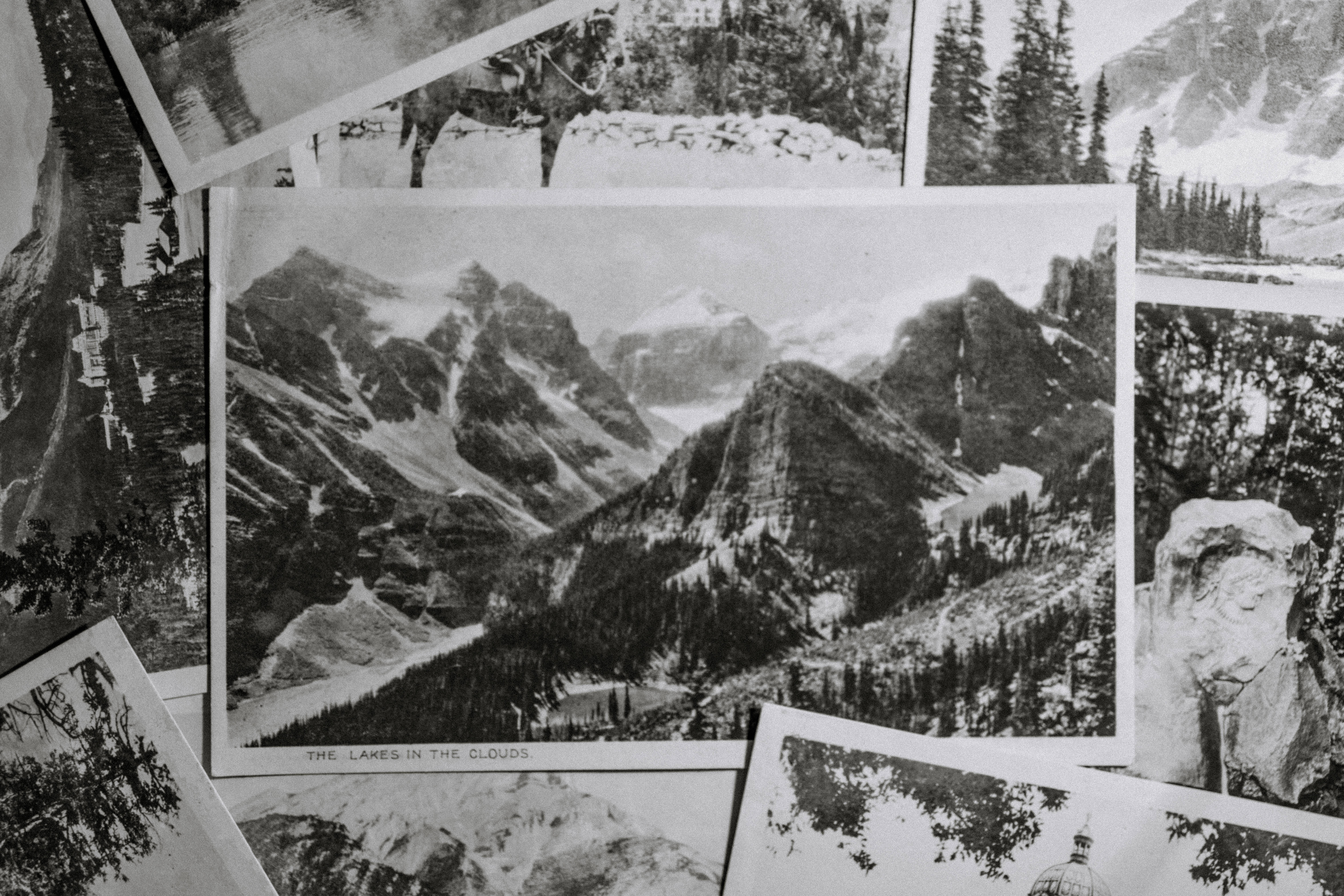 black aesthetic collage 桌布 壁紙 — 復古黑白明信片，描繪山區風景，散落並重疊在表面上。