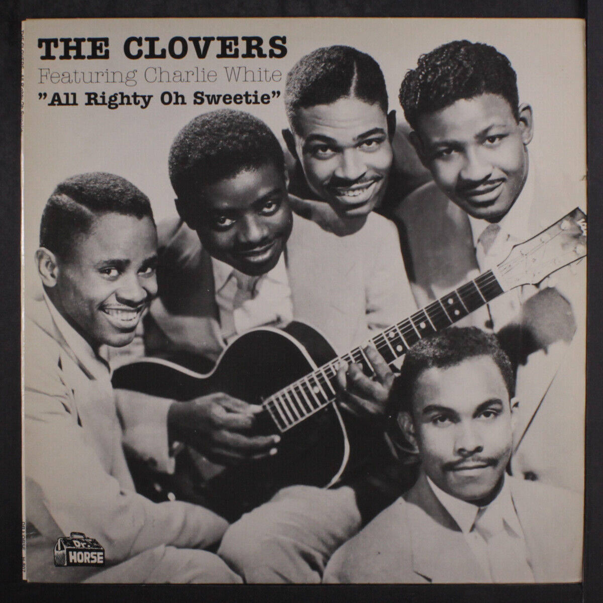 artist 桌布 壁紙 — 復古黑白照片，The Clovers 在唱片專輯封面上圍著原聲吉他溫暖微笑。