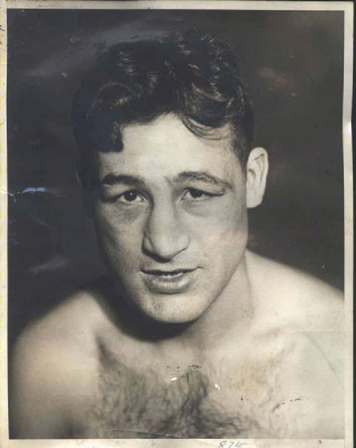 Boxing 桌布 壁紙 — 復古黑白肖像，一名赤裸上身的男子，眼神銳利，頭髮有紋理，背景為深色攝影棚。