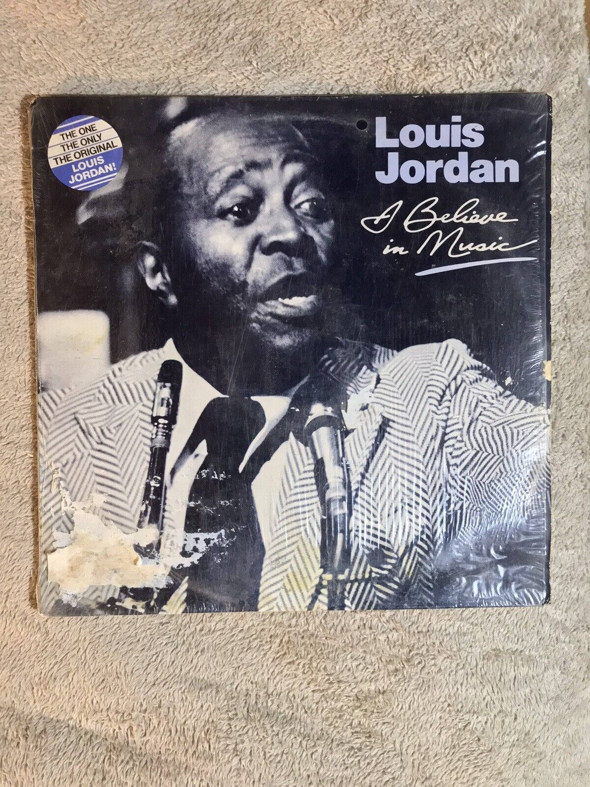 album 桌布 壁紙 — 復古黑膠唱片封面，路易斯·喬丹在質感米色地毯上對著麥克風唱歌。