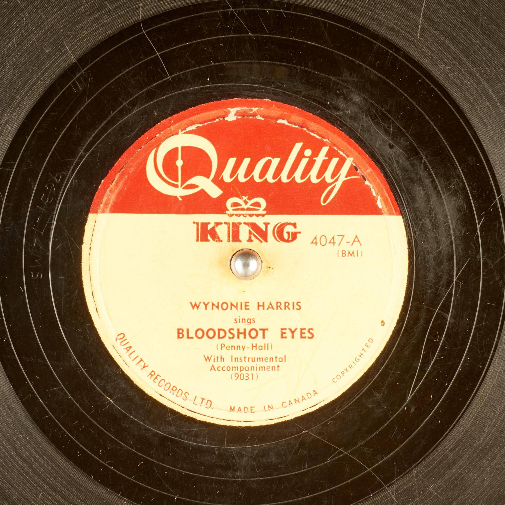 vinyl 桌布 壁紙 — 復古黑色黑膠唱片標籤的特寫，帶有紅色和奶油色文字，顯示 Wynonie Harris 演唱 Bloodshot Eyes。