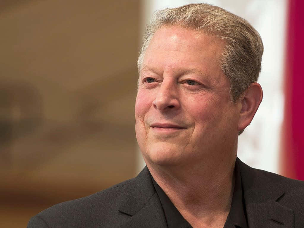 Celebrity 桌布 壁紙 — 微笑中年男子身穿深色西裝的特寫肖像，背景為柔和模糊的室內環境。