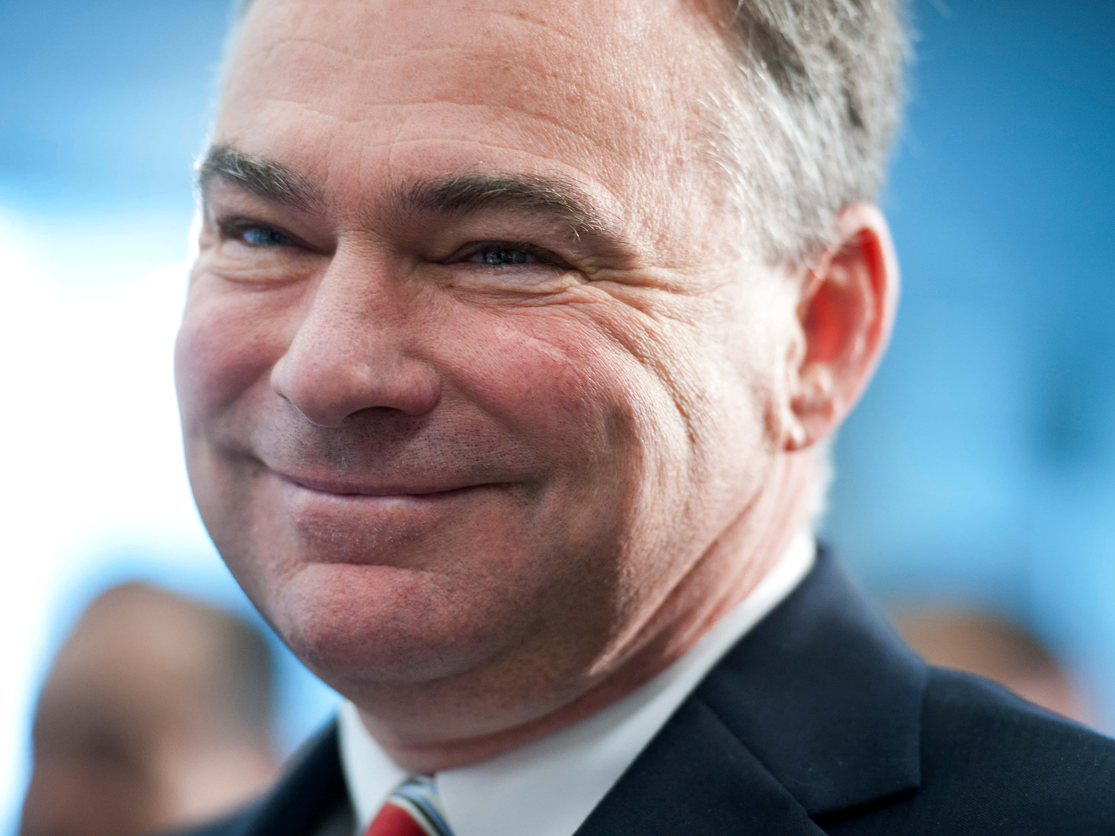 Celebrity 桌布 壁紙 — 微笑中年男子身穿西裝的 close-up，背景為模糊藍色。