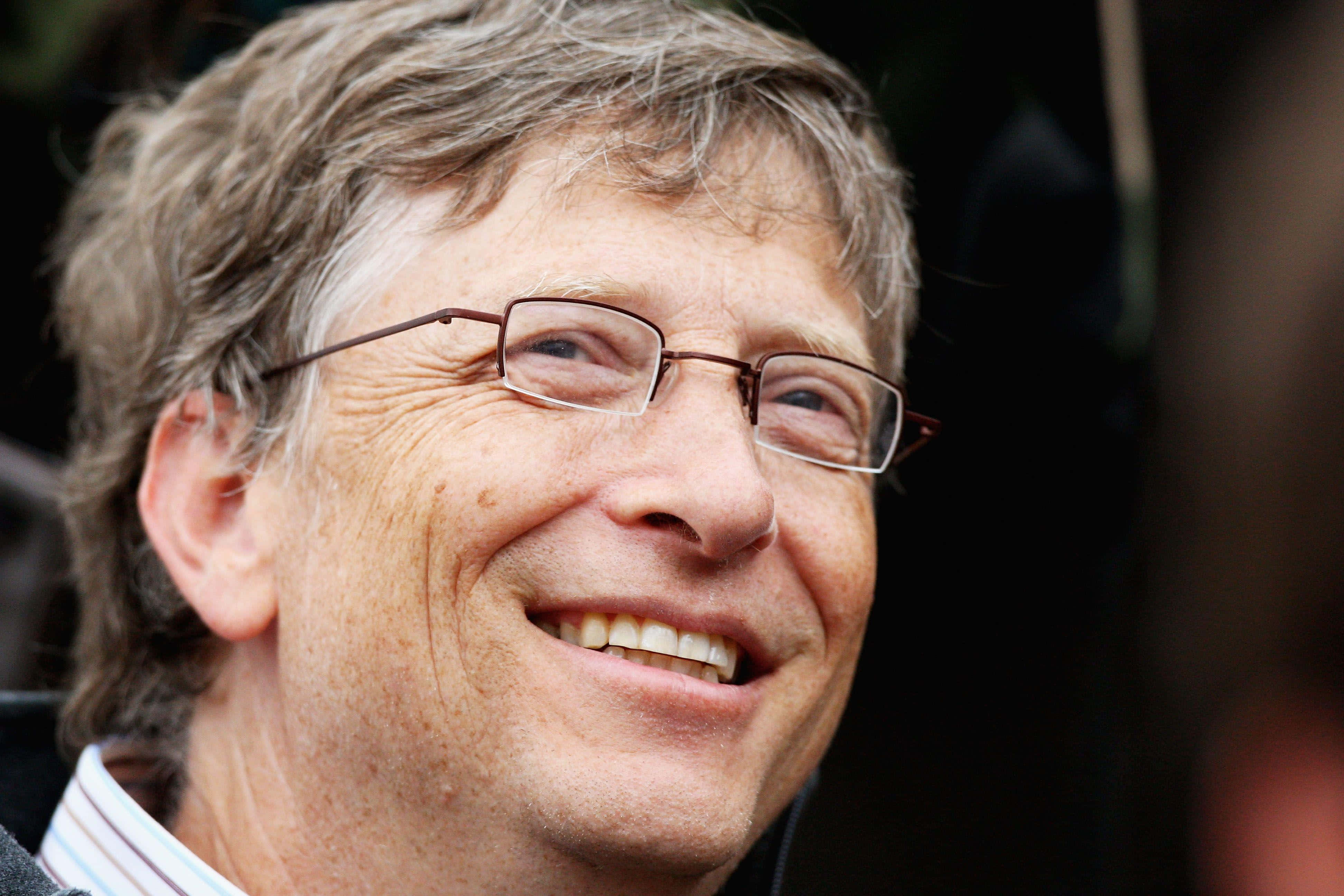 Bill Gates 桌布 壁紙 — 微笑男士戴眼鏡及灰白頭髮的頭像特寫，背景為深色模糊。