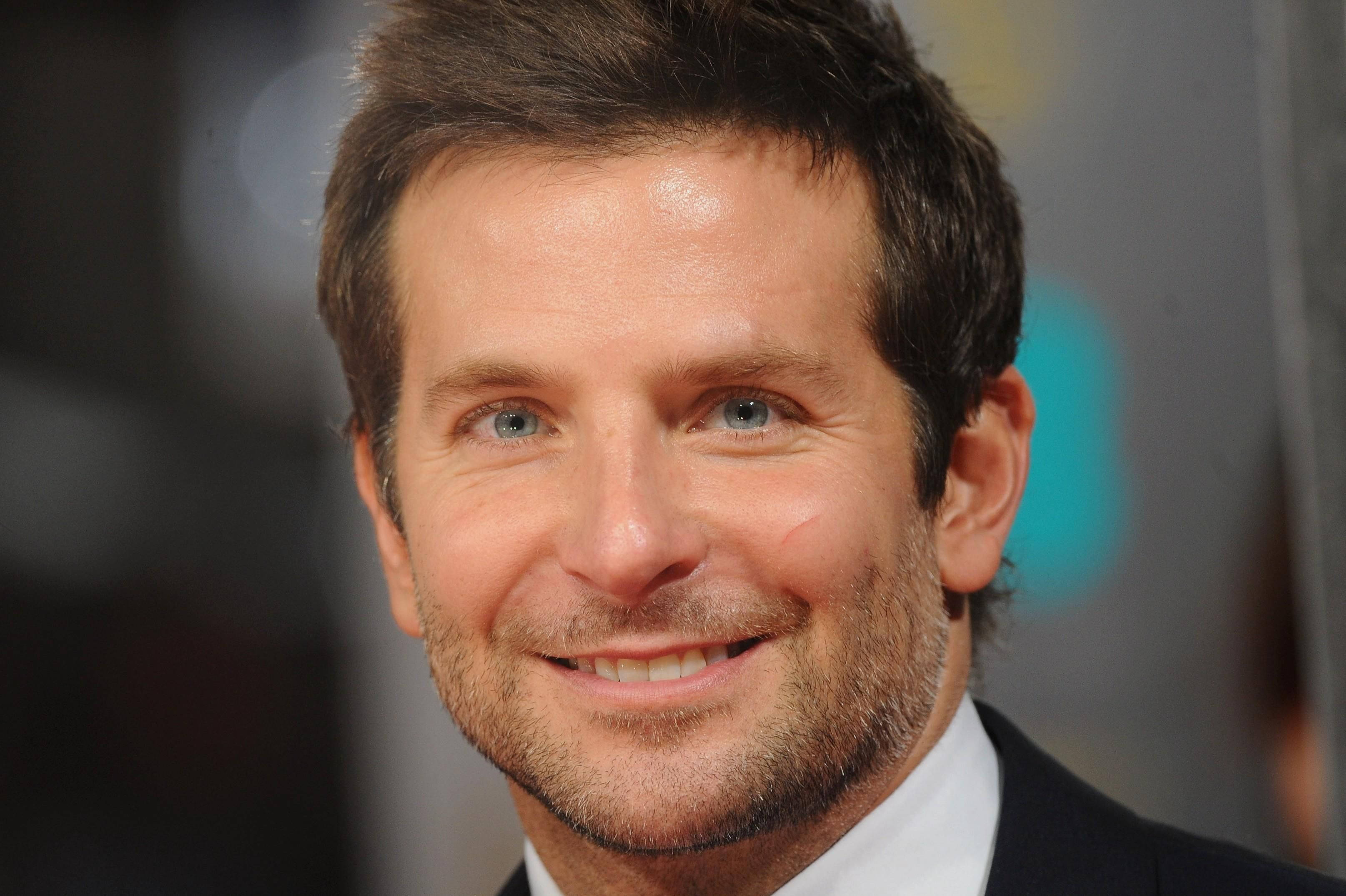 Bradley Cooper 桌布 壁紙 — 微笑男士的頭像特寫，藍眼睛、鬍渣，身穿西裝和白襯衫。