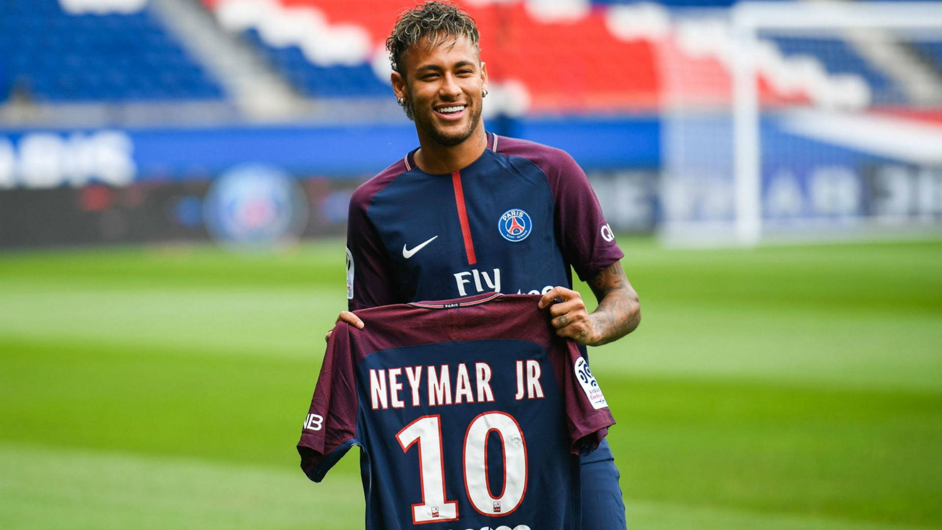 內馬爾微笑著在足球場上拿著他的PSG 10號球衣。 — 内马尔 壁紙