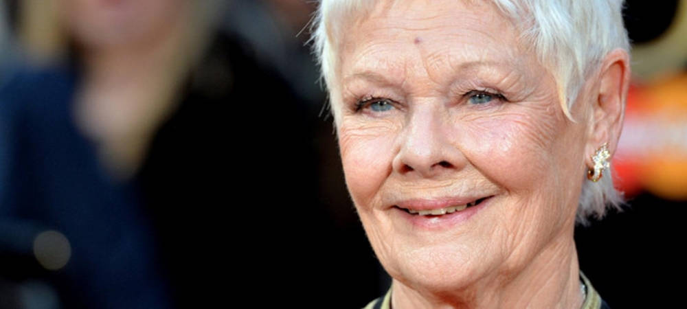 Judi Dench 桌布 壁紙 — 微笑的老年婦女特寫肖像，短白髮，藍眼睛，戴著優雅耳環。