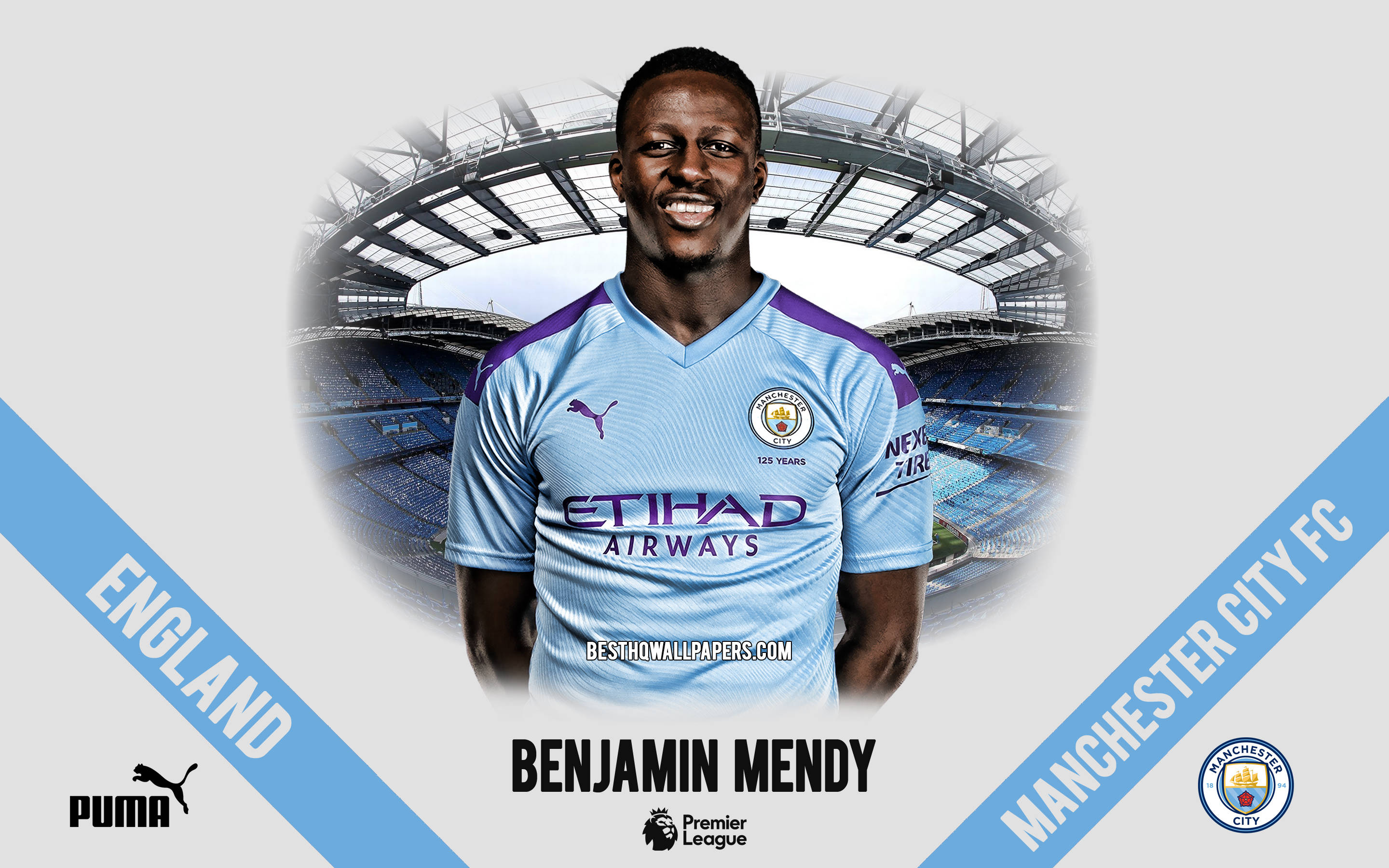 Mendy 桌布 壁紙 — 微笑的足球員班傑明門迪身穿曼城球衣，站在有品牌元素的球場背景前。