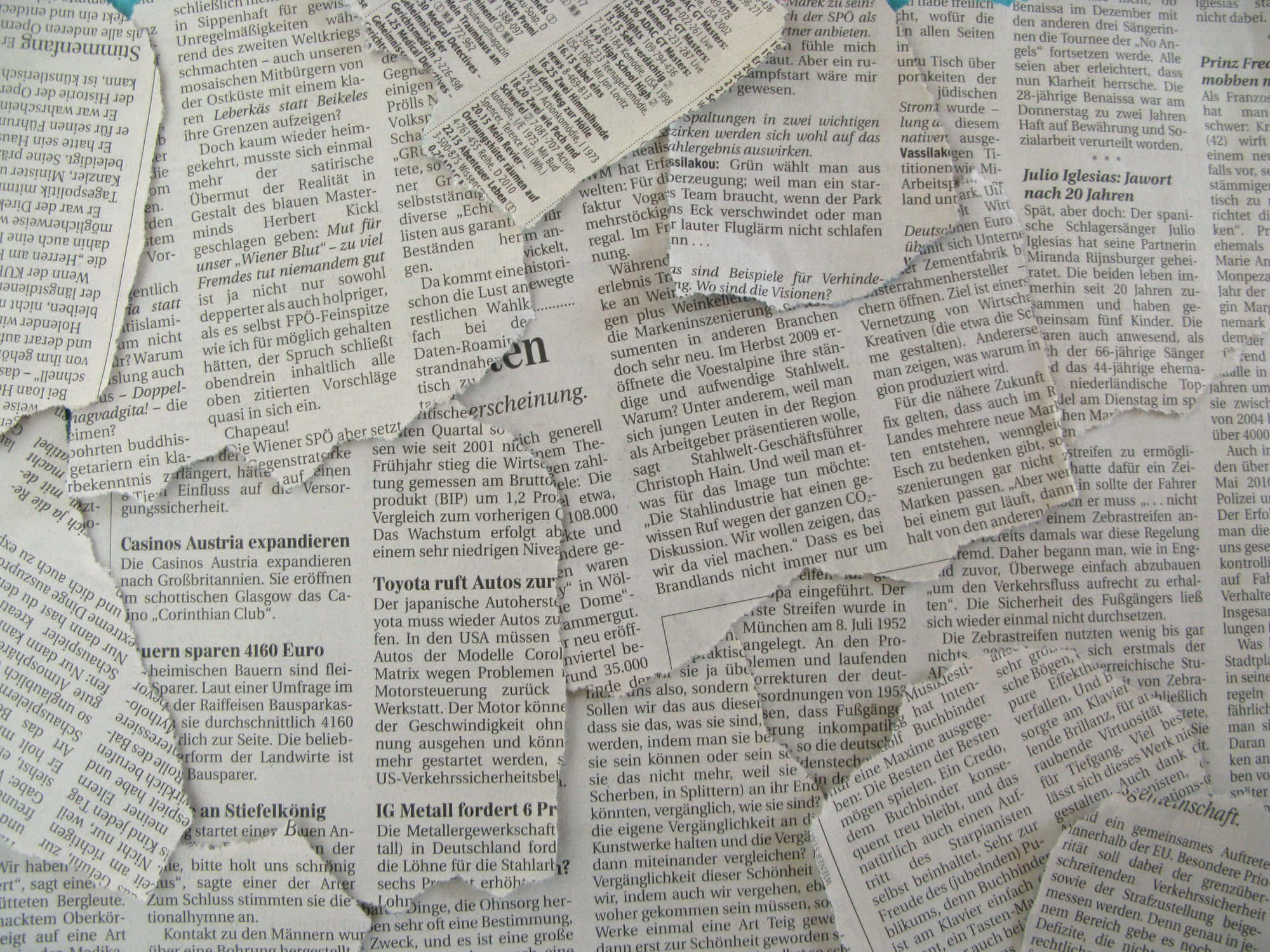 Old Newspaper 桌布 壁紙 — 德國報紙文字的近距離特寫，內容密集，帶有粗體標題和細小字體，印在舊紙上。