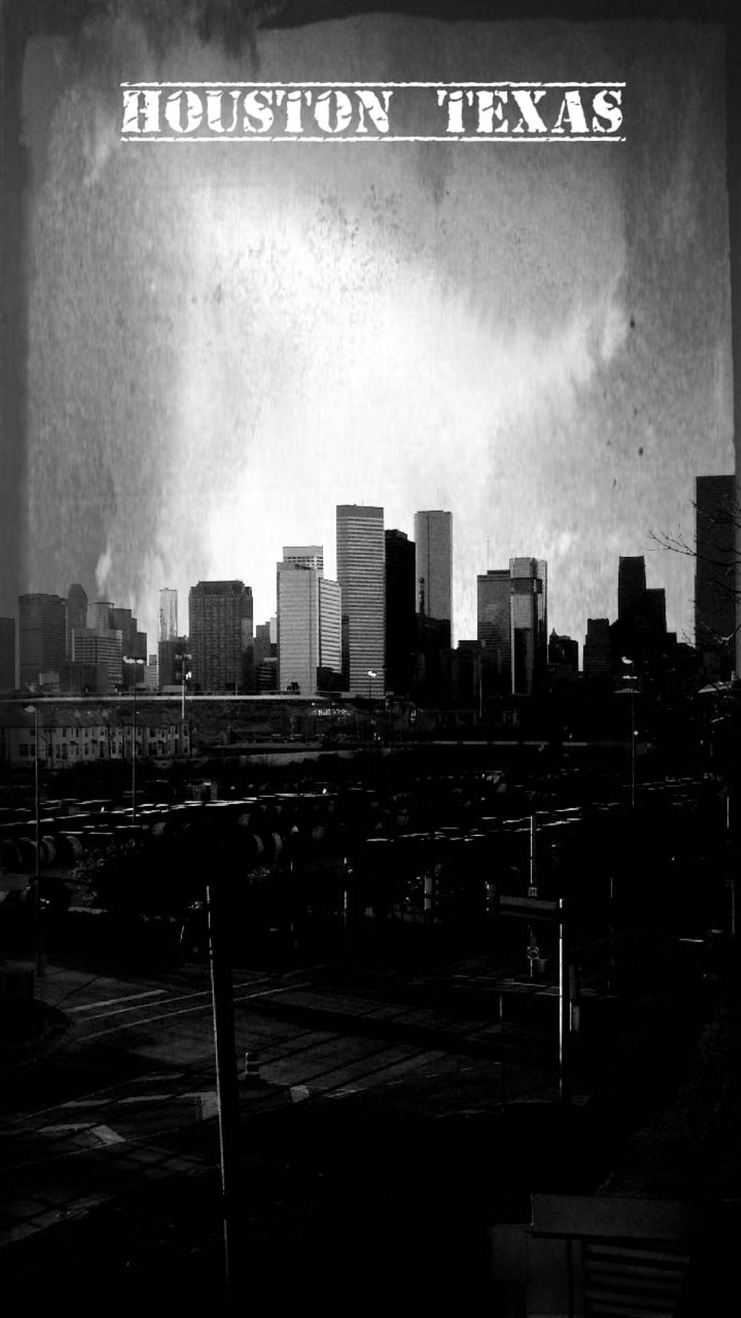 Houston 桌布 壁紙 — 德州休士頓一幅粗獷的黑白城市景觀，高聳的摩天大樓在暴風雨的天空下形成剪影。