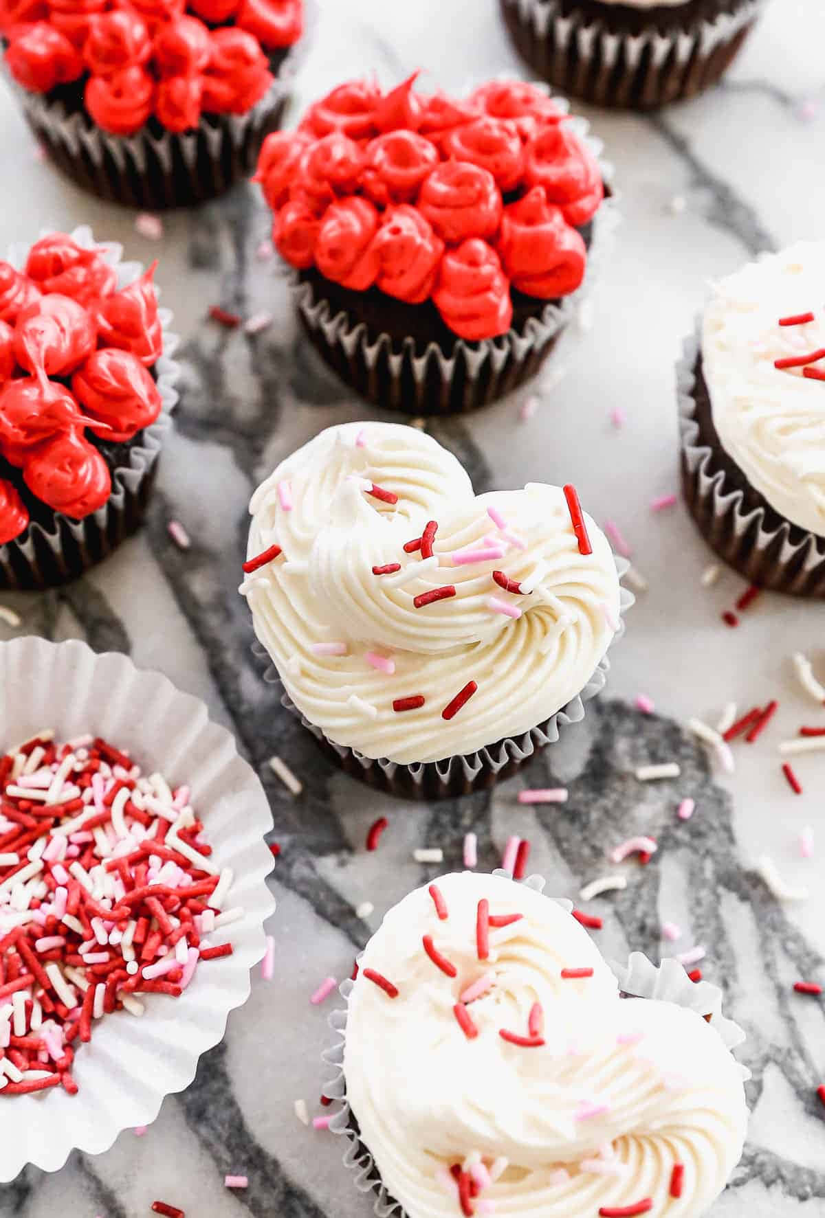 Cupcake 桌布 壁紙 — 心形 cupcakes 配上紅色和白色糖霜及裝飾糖粒，置於大理石表面上。