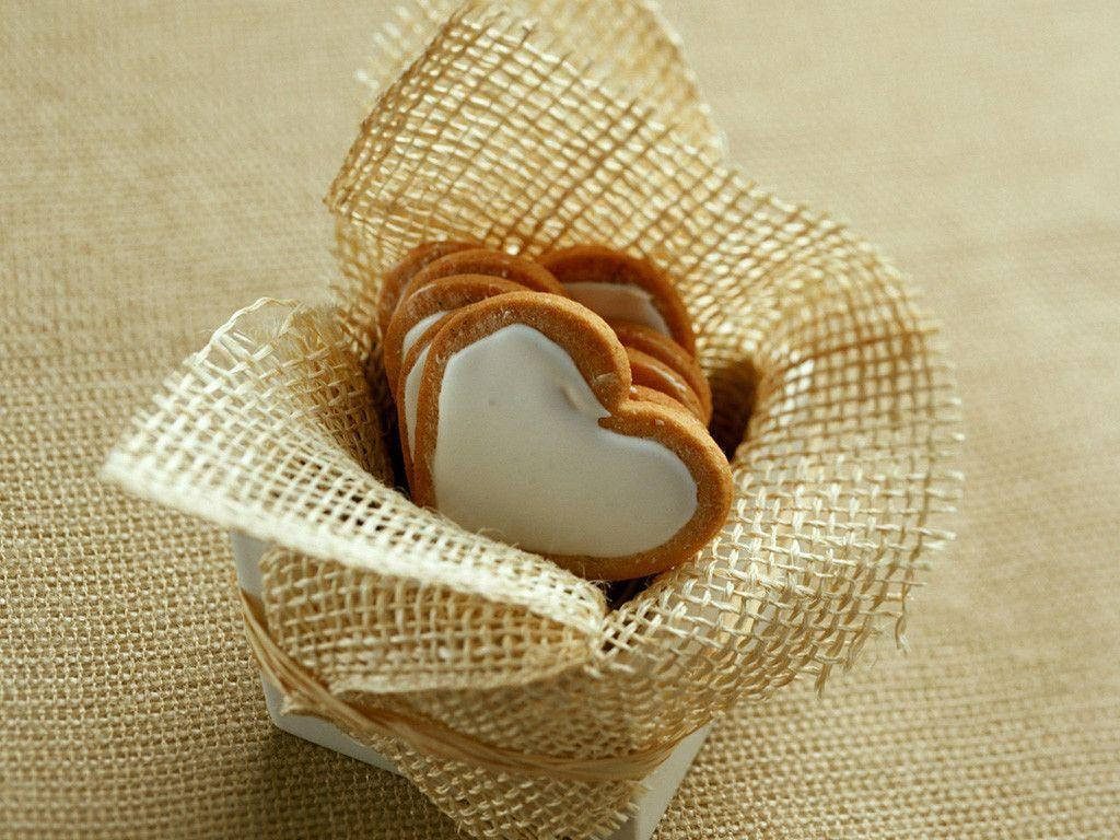 Cute Heart 桌布 壁紙 — 心形餅乾搭配白色糖霜，放在一個用粗麻布包裹的盒子裡，置於有紋理的米色表面上。
