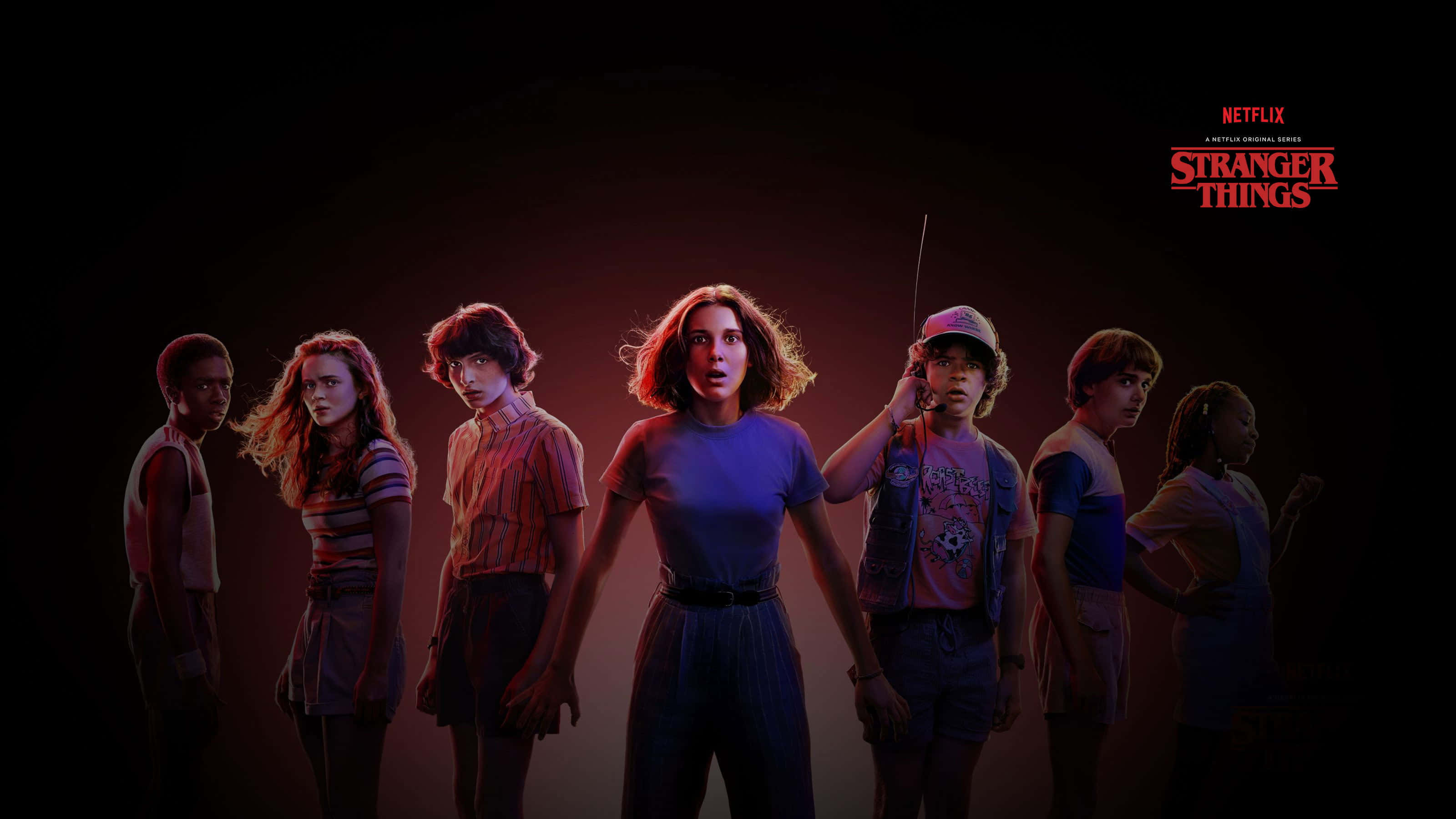 Netflix 桌布 壁紙 — 《怪奇物語》中的七個年輕角色站在一條被詭異紅藍燈光照亮的黑暗隧道中，表情震驚。