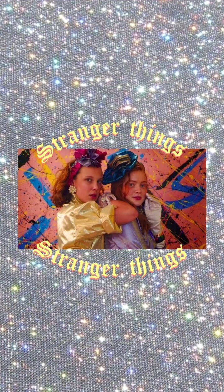 Stranger Things Aesthetic 桌布 壁紙 — 《怪奇物語》中的兩個女孩在閃爍的宇宙背景前擺姿勢，劇集標題在上方和下方呈拱形。