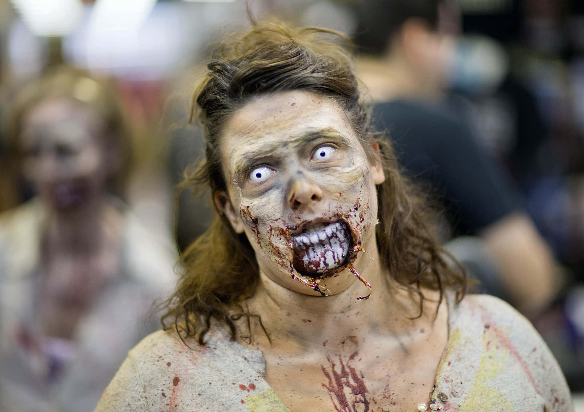 Zombie Apocalypse 桌布 壁紙 — 恐怖活動中，一名化著殭屍妝的女子特寫，嘴巴沾滿鮮血，眼睛睜大。