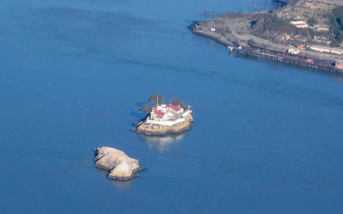 California Island 桌布 壁紙 — 惡魔島的鳥瞰圖，歷史悠久的監獄建築和紅色屋頂被深藍色的海水包圍。