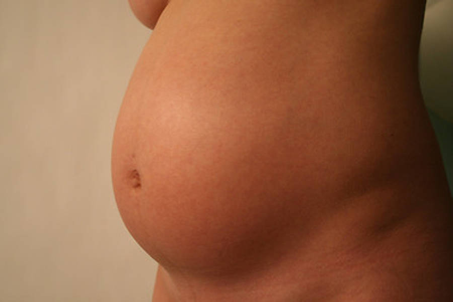 Pregnant 桌布 壁紙 — 懷孕肚子的特寫，皮膚柔軟，可見妊娠紋，背景為中性色。