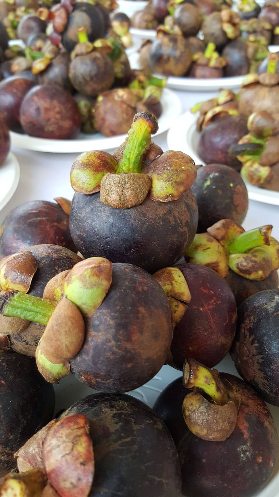 Fruit 桌布 壁紙 — 成熟山竹的特寫，深紫色外皮和綠色莖部堆疊在白盤上。