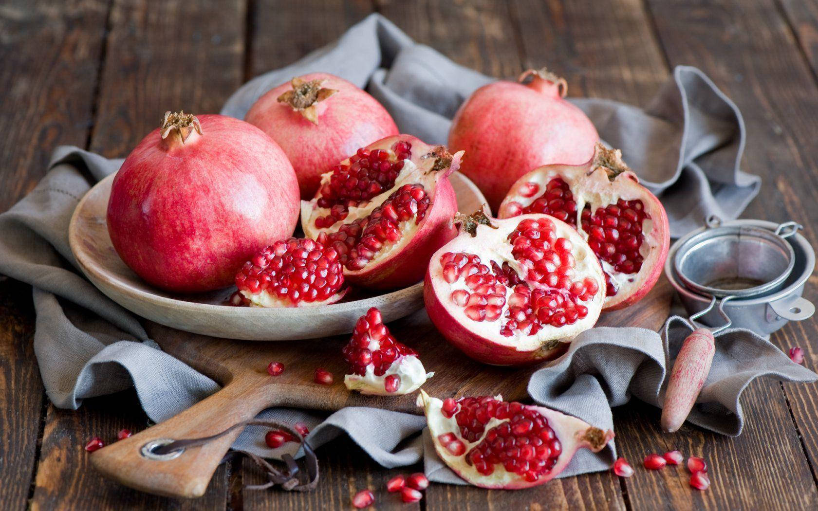 Fruit 桌布 壁紙 — 成熟的石榴爆滿紅寶石般的籽，放在鋪有灰色布的木板之上。