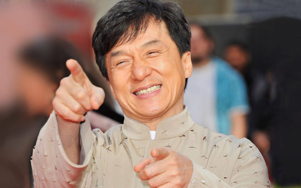快樂 桌布 壁紙 — 成龍露出燦爛笑容，愉快地伸出雙指向前指。