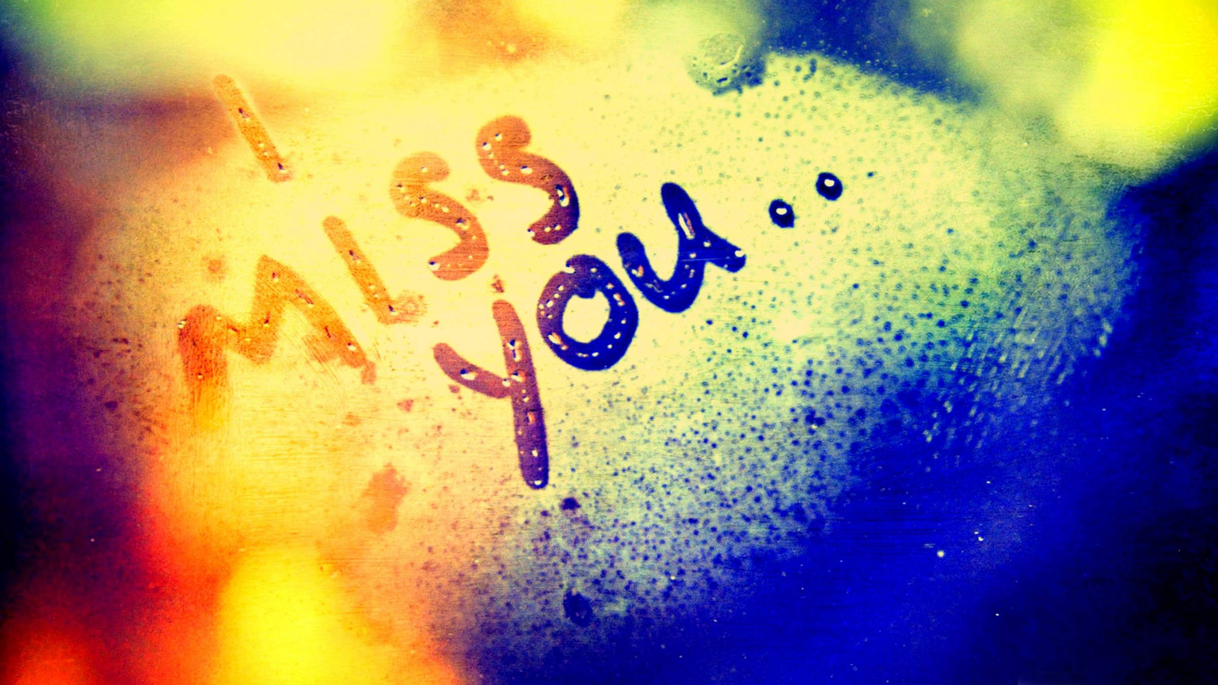 I Miss You 桌布 壁紙 — 「我想你」這幾個字寫在佈滿雨點的玻璃窗上，溫暖的黃色和冷調的藍色漸變在玻璃上交織。
