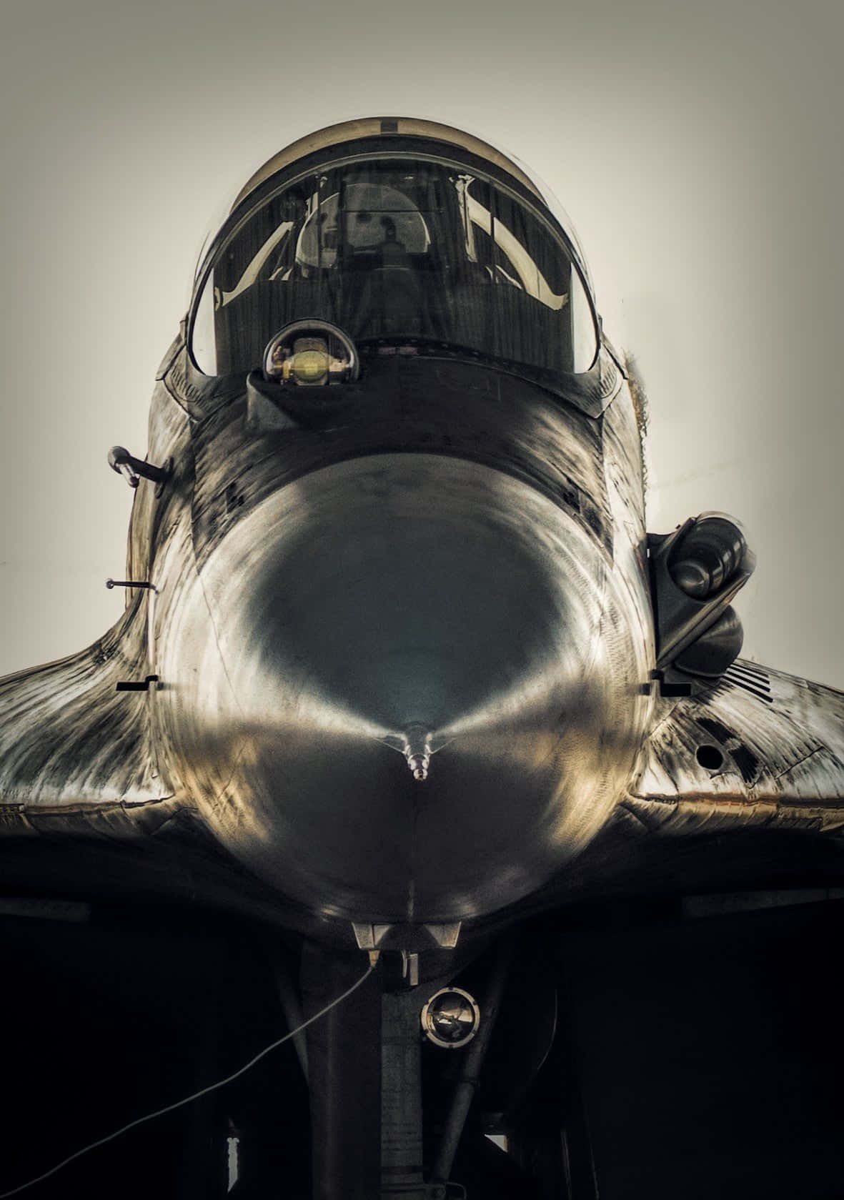 Android Jumbo Jets 桌布 壁紙 — 戰鬥機機鼻錐和駕駛艙的特寫，帶有金屬光澤和戲劇性燈光。