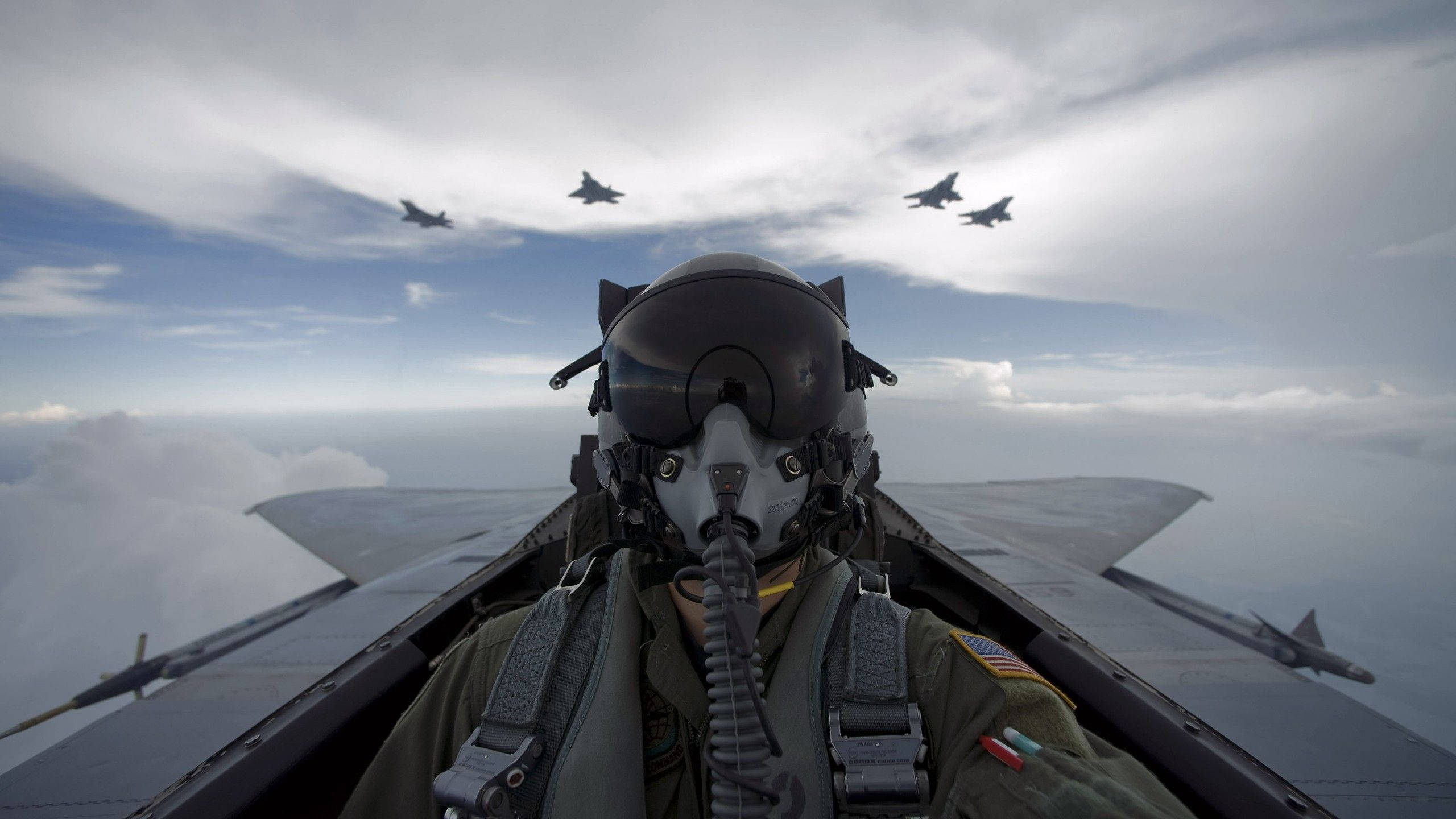 軍事動圖 桌布 壁紙 — 戰鬥機駕駛艙內的飛行員，四架噴射機在部分多雲的天空下，在雲層上方編隊飛行。