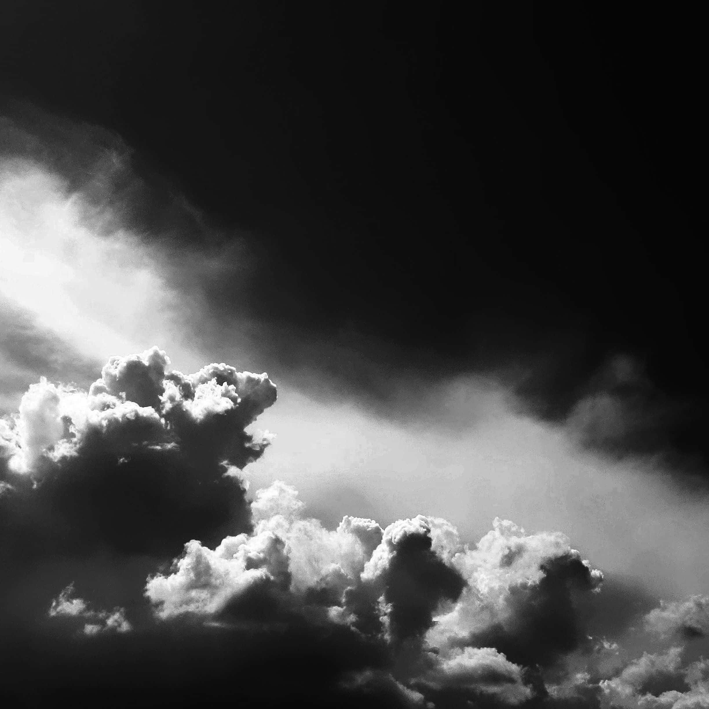 Black And White Sky 桌布 壁紙 — 戲劇性的單色雲層，明亮照亮的山峰與深邃陰影的山谷之間形成鮮明對比。