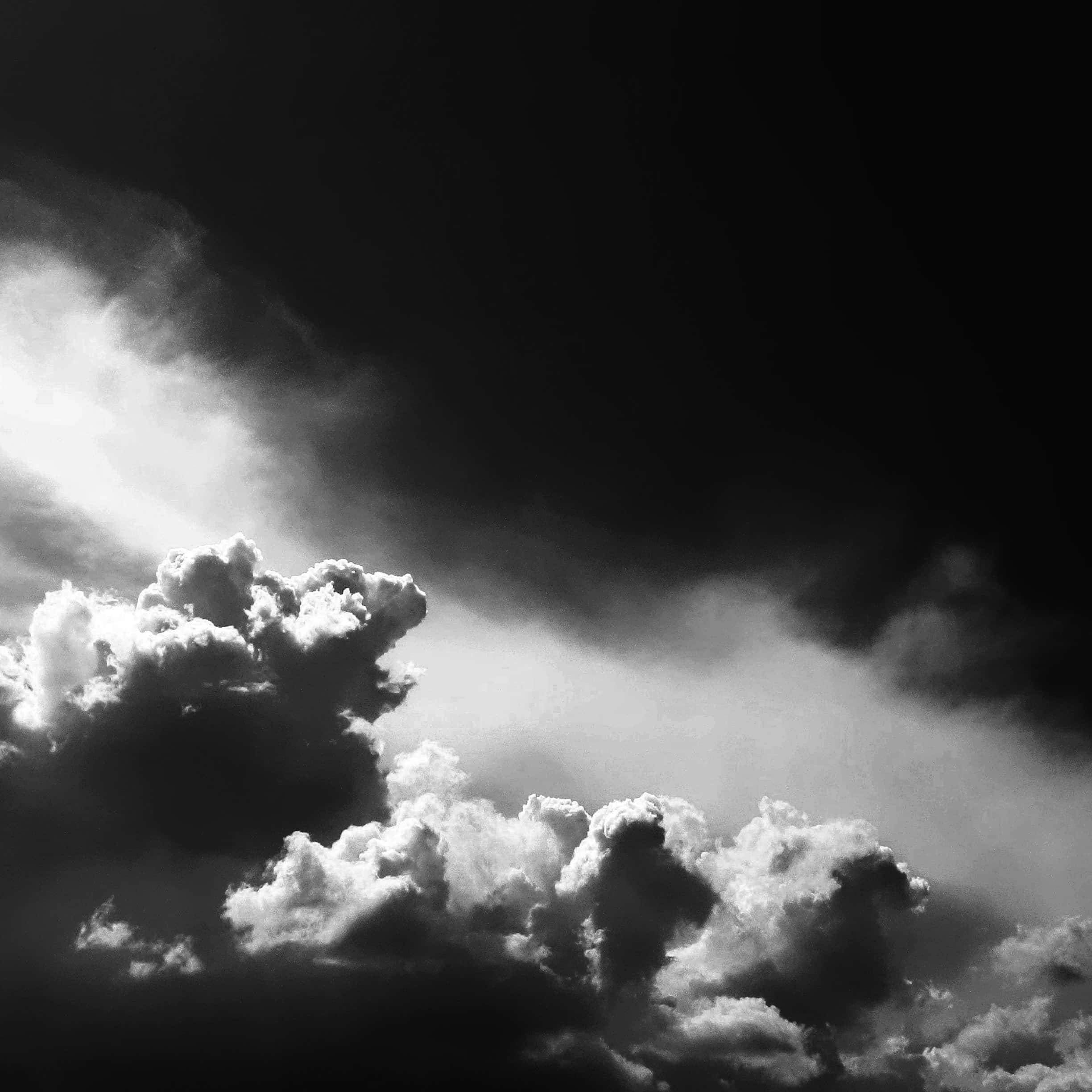 Black And White Sky 桌布 壁紙 — 戲劇性的單色雲層，明亮照亮的山峰與深邃陰影的山谷形成鮮明對比。