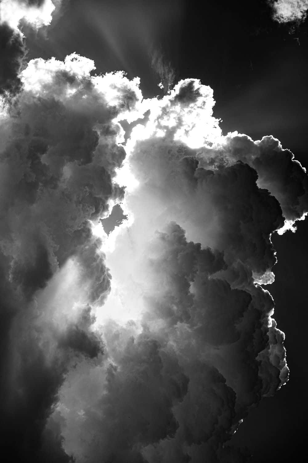 Black And White Sky 桌布 壁紙 — 戲劇性的單色雲層，被刺眼的陽光穿透，映襯著黑暗的天空。