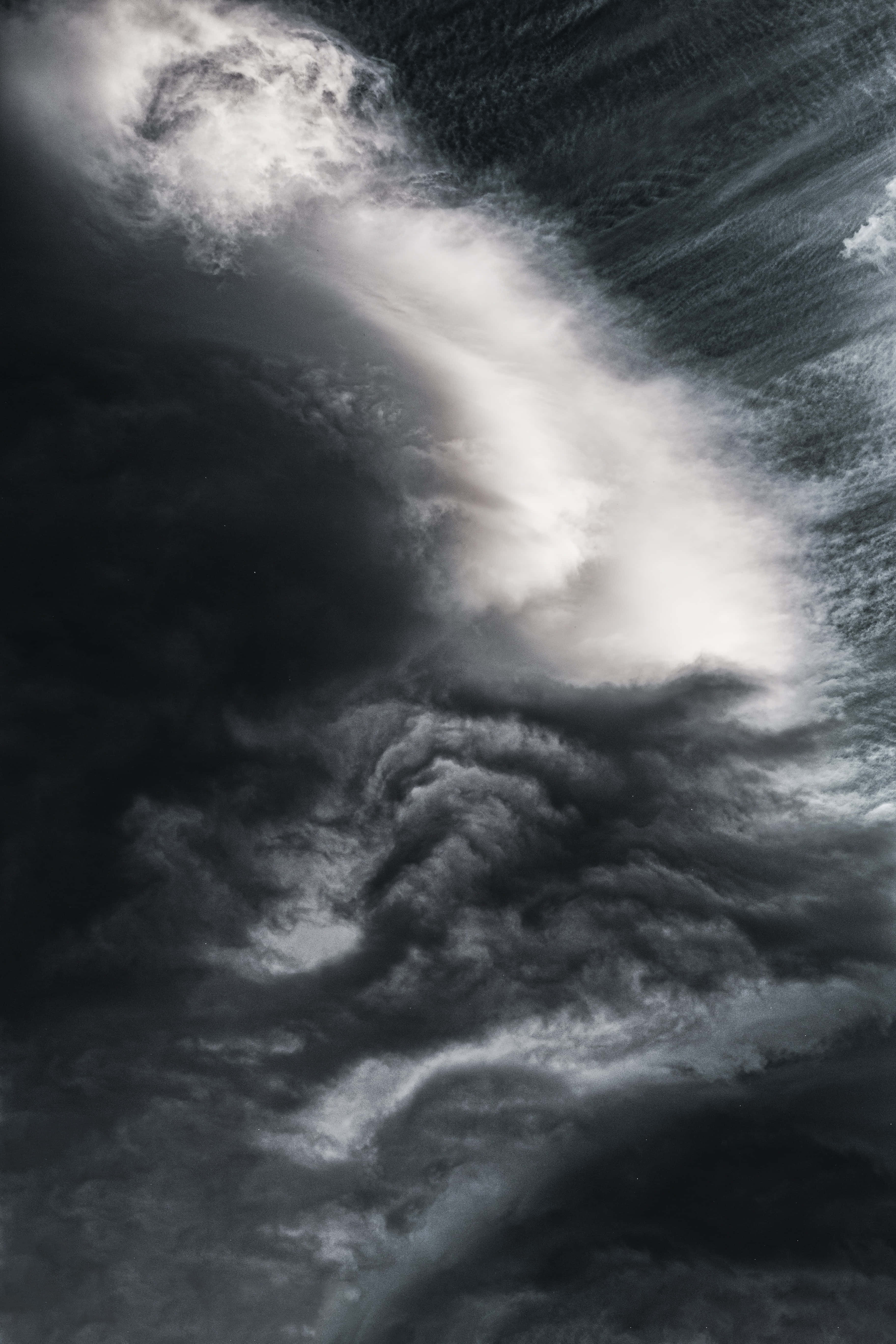 Dark Heaven 桌布 壁紙 — 戲劇性的單色雲層在湍流運動中旋轉，明亮白色與深邃陰影之間形成鮮明對比。