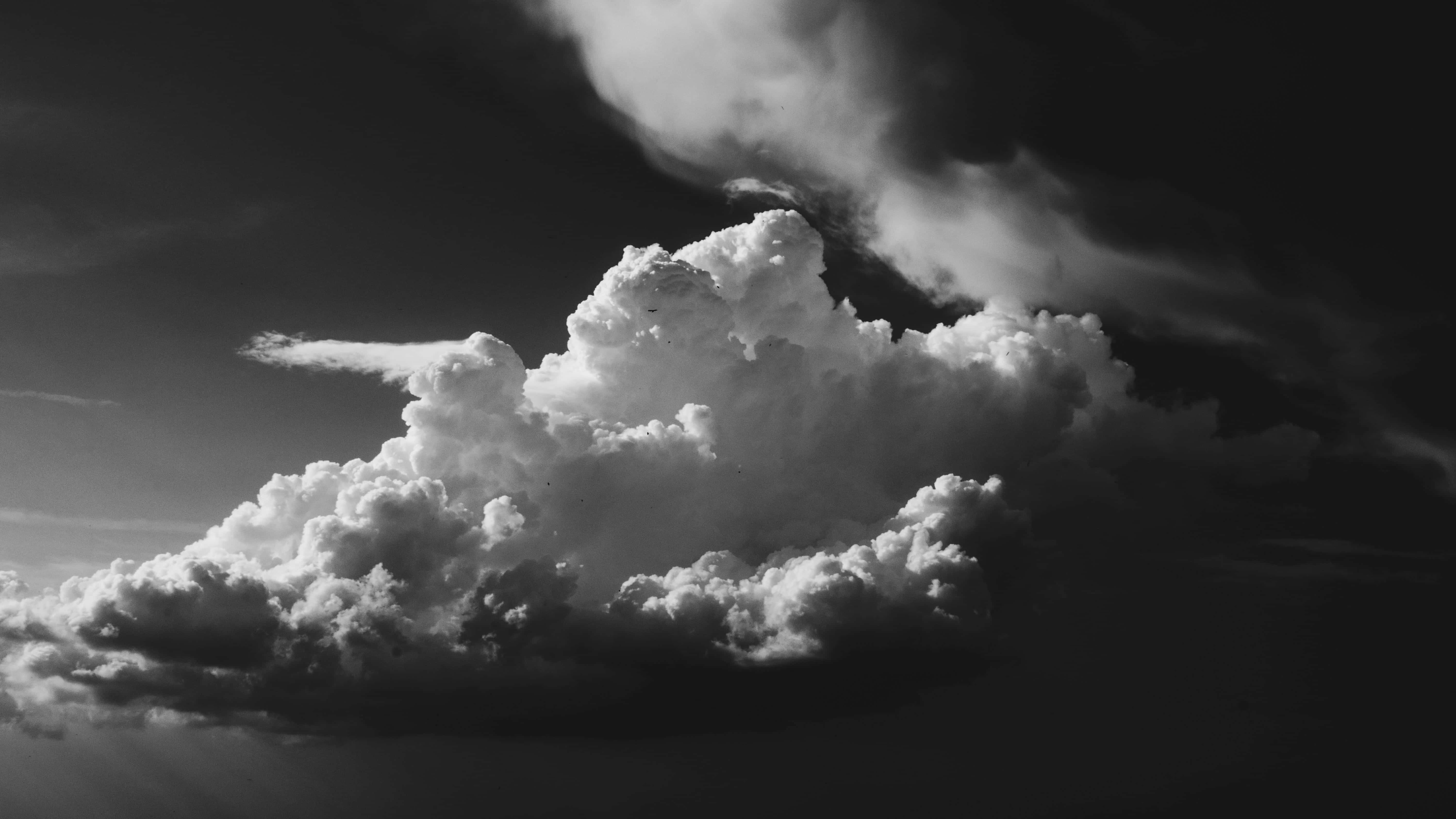 Dark Heaven 桌布 壁紙 — 戲劇性的單色雲層在黑暗天空中聳立，呈現強烈對比和紋理細節。