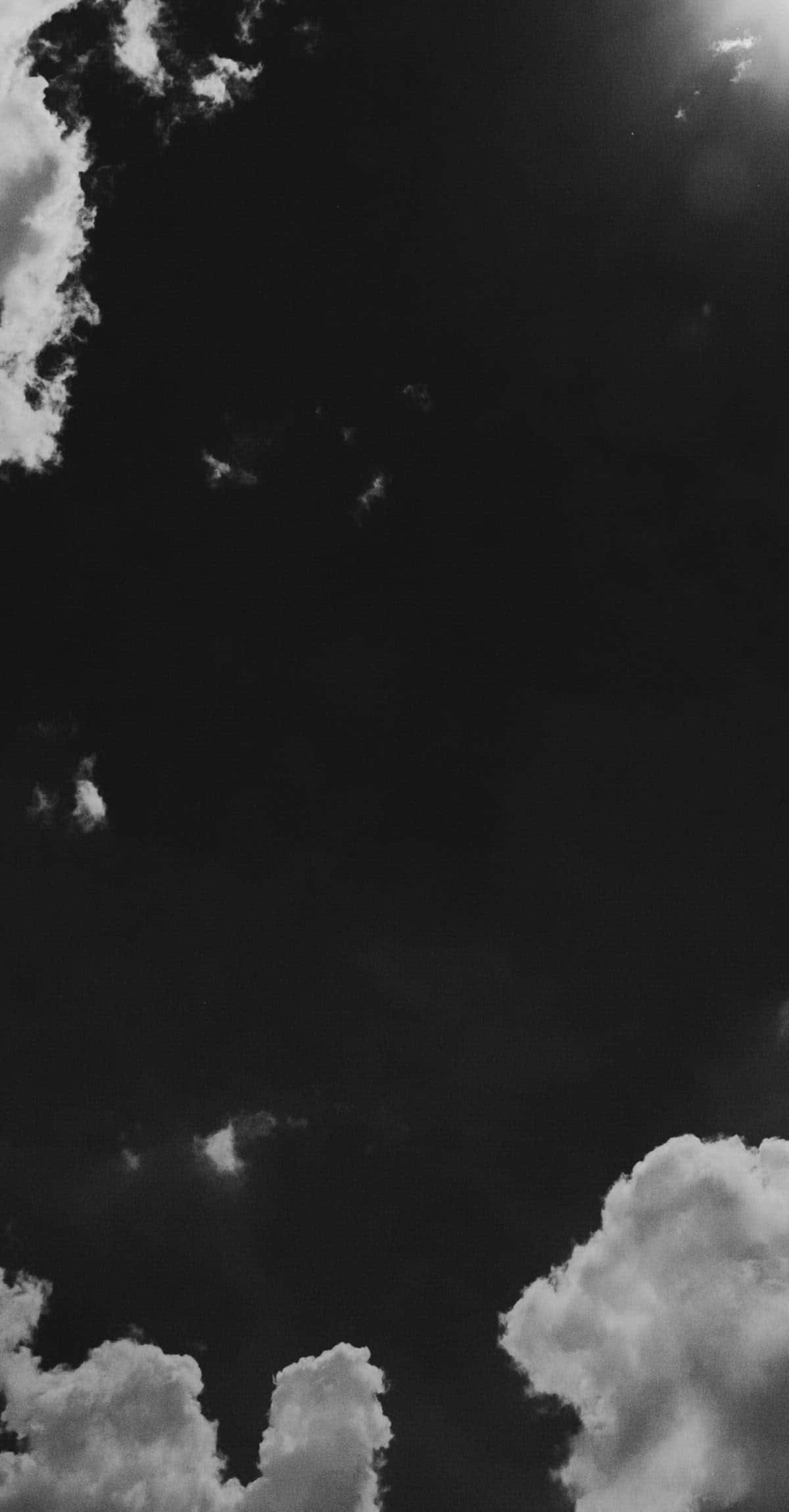 Black And White Storm 桌布 壁紙 — 戲劇性的單色雲朵在深邃的黑色天空中飄移，呈現強烈對比和柔和質感。