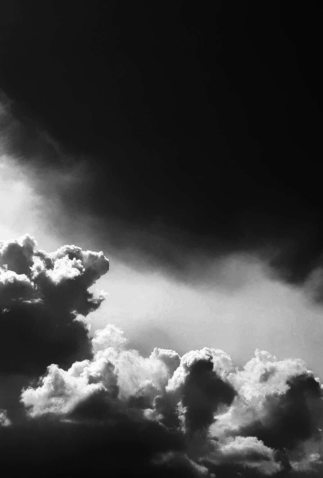 Black And White Cloud 桌布 壁紙 — 戲劇性的單色雲朵在深黑色天空中形成強烈對比，呈現高對比度的黑白照片效果。