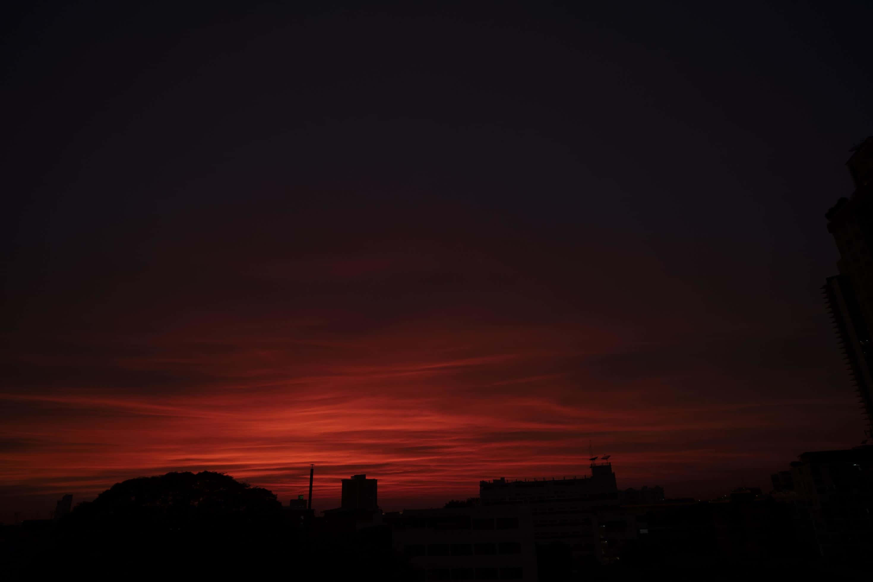 Aesthetic Sky 桌布 壁紙 — 戲劇性的城市天際線，在火紅橙色的日落天空襯托下呈現剪影。