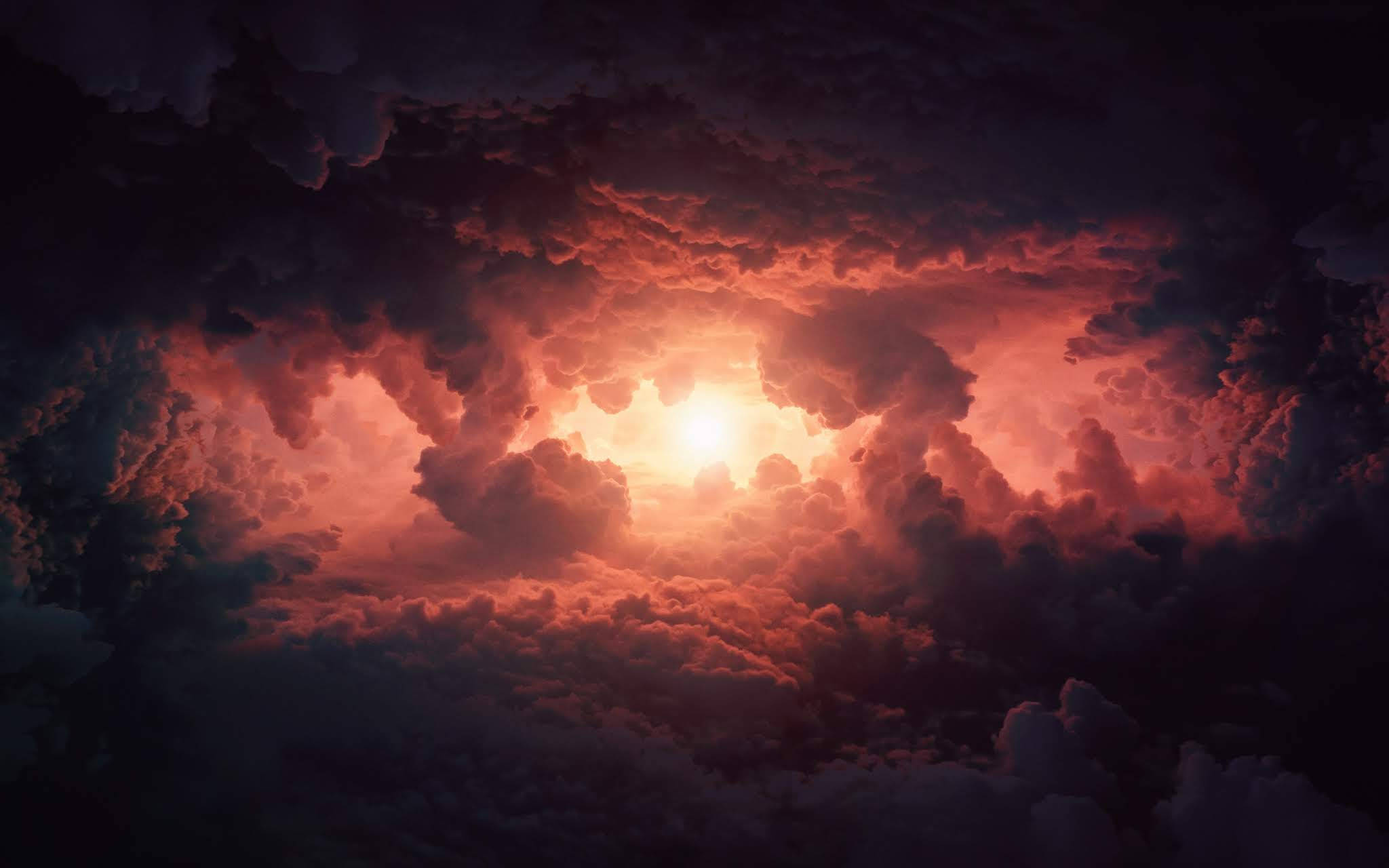 Heavenly Clouds 桌布 壁紙 — 戲劇性的天空，明亮的太陽穿過濃密的雲層，發出火紅和橙色的光芒。