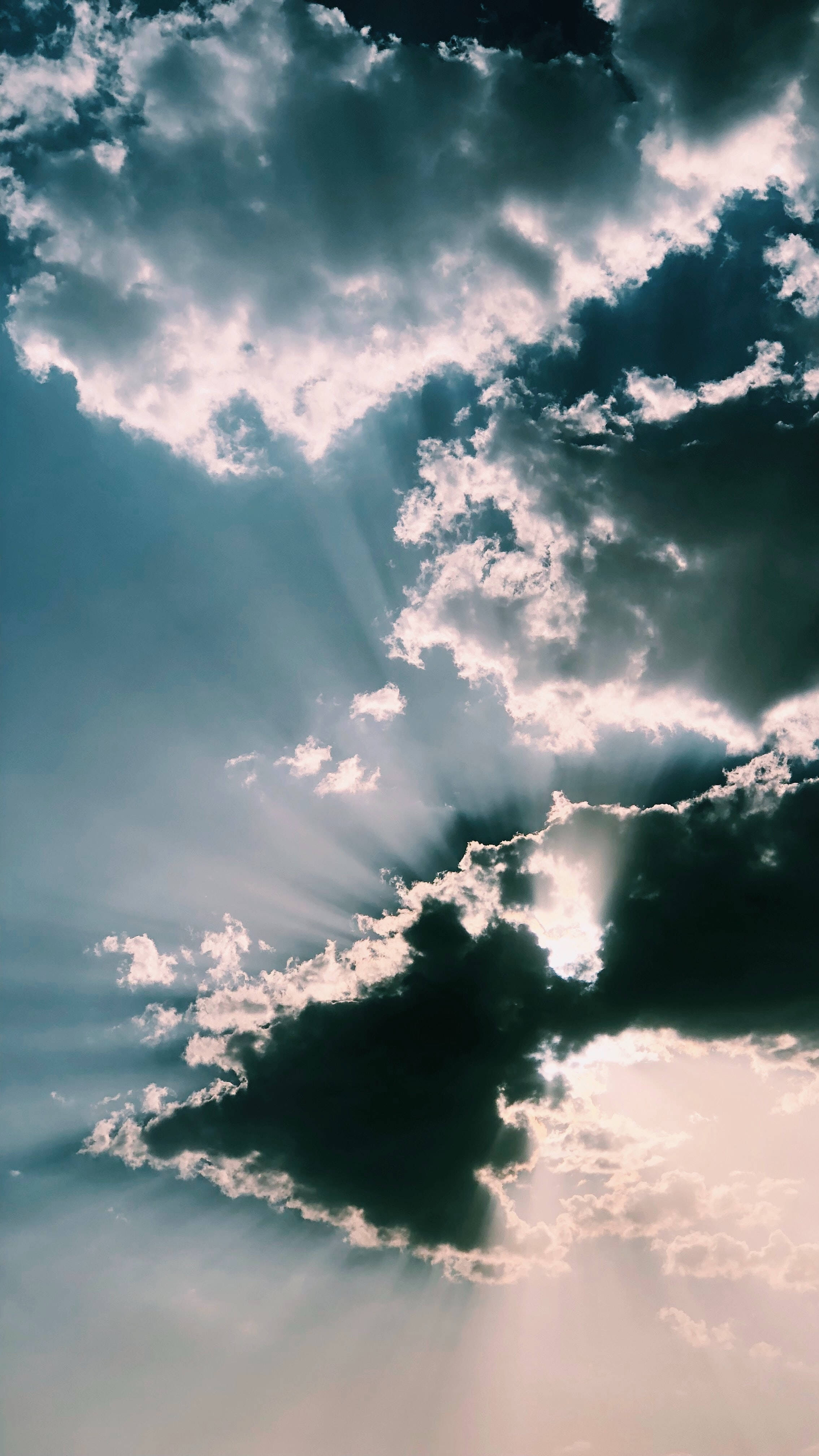 雲朵 桌布 壁紙 — 戲劇性的天空，烏雲被燦爛的陽光穿透，投射出空靈的光芒。