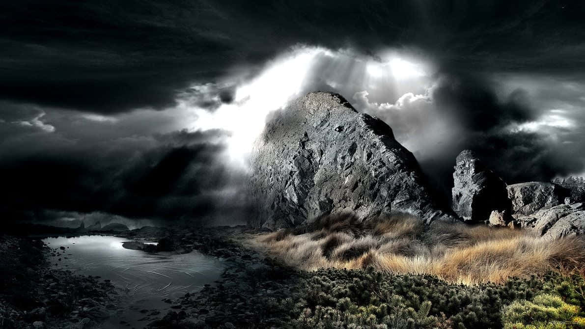 Dark Nature 桌布 壁紙 — 戲劇性的山峰刺穿黑暗的風暴雲，神聖的光芒穿透雲層，照耀在霧氣瀰漫的湖泊和崎嶇的地形之上。