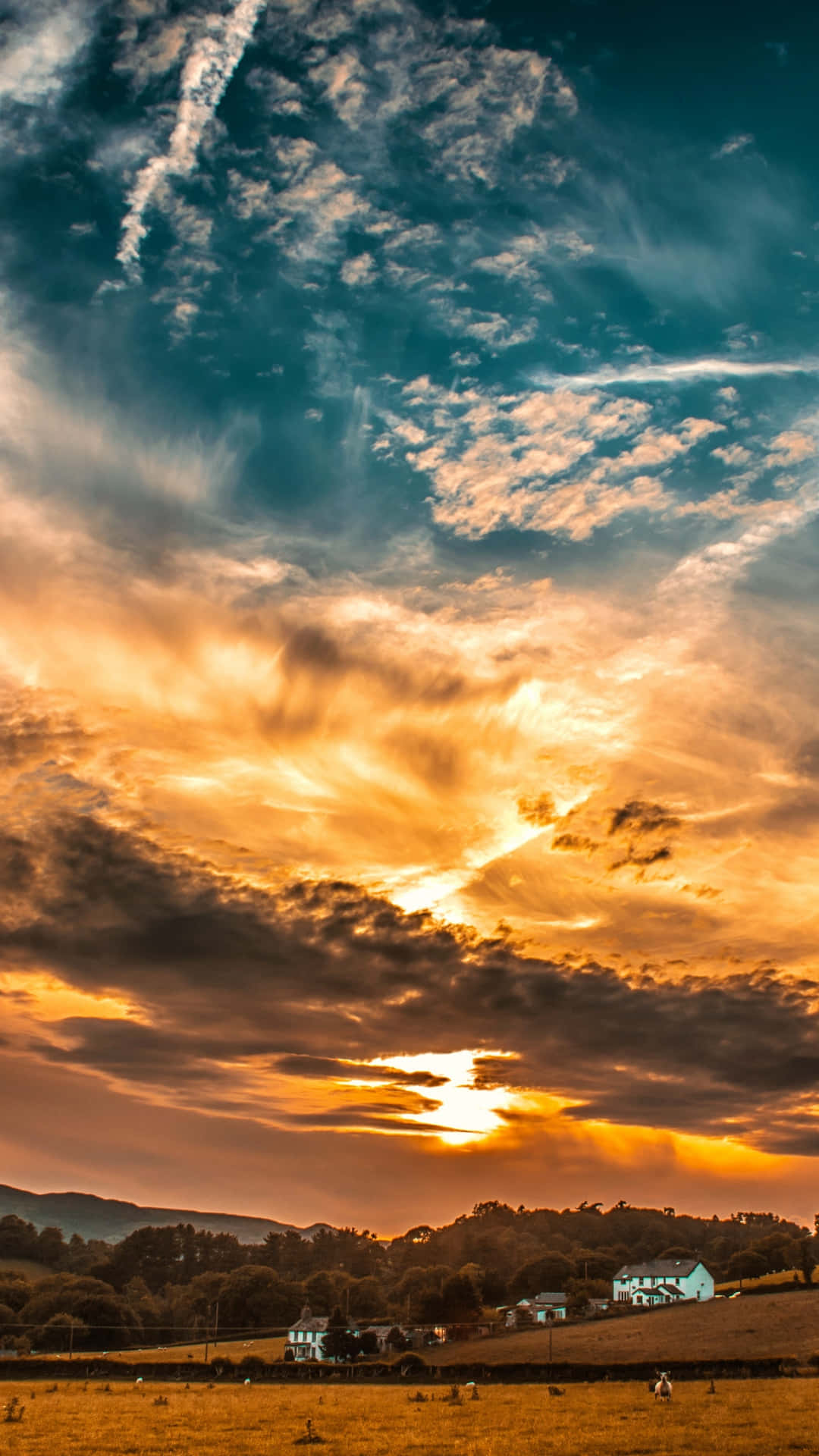 Clouds Aesthetics 桌布 壁紙 — 戲劇性的日落將天空染成火熱的橙色和深藍色，雲朵在寧靜的鄉村上空盤旋，散落著房屋。