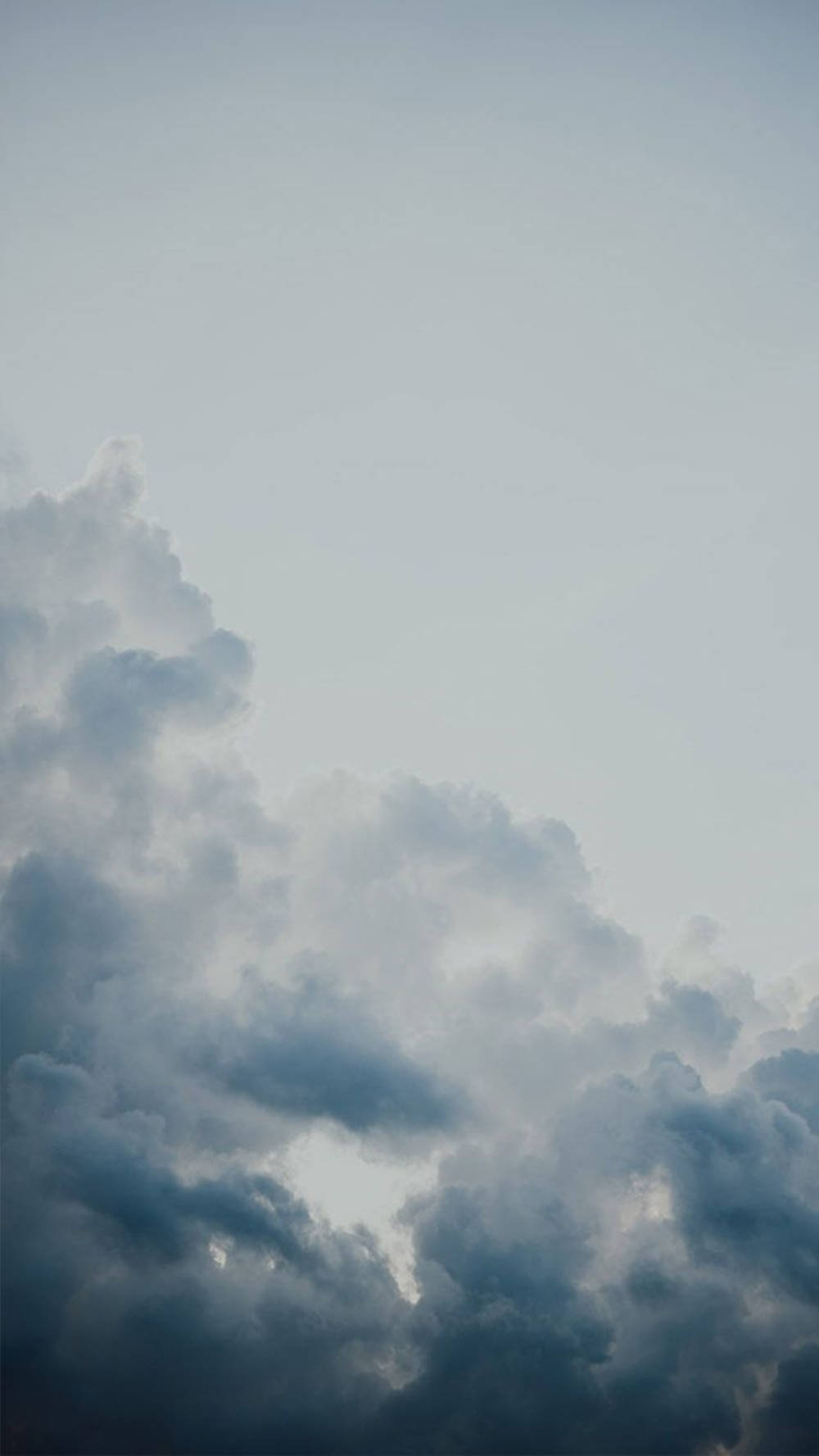 雲朵 桌布 壁紙 — 戲劇性的暴風雲在陰鬱的暮色天空中聚集，帶有柔和的灰色和藍色漸變。