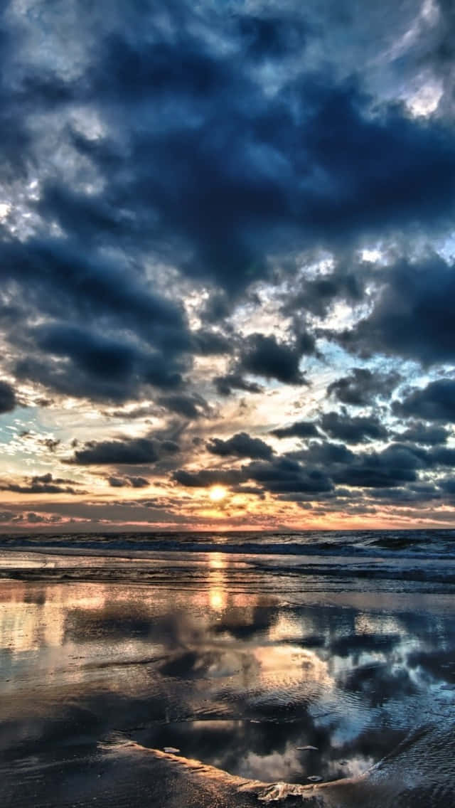 海上日落，雲朵倒映在濕沙上。 — 天堂 壁紙