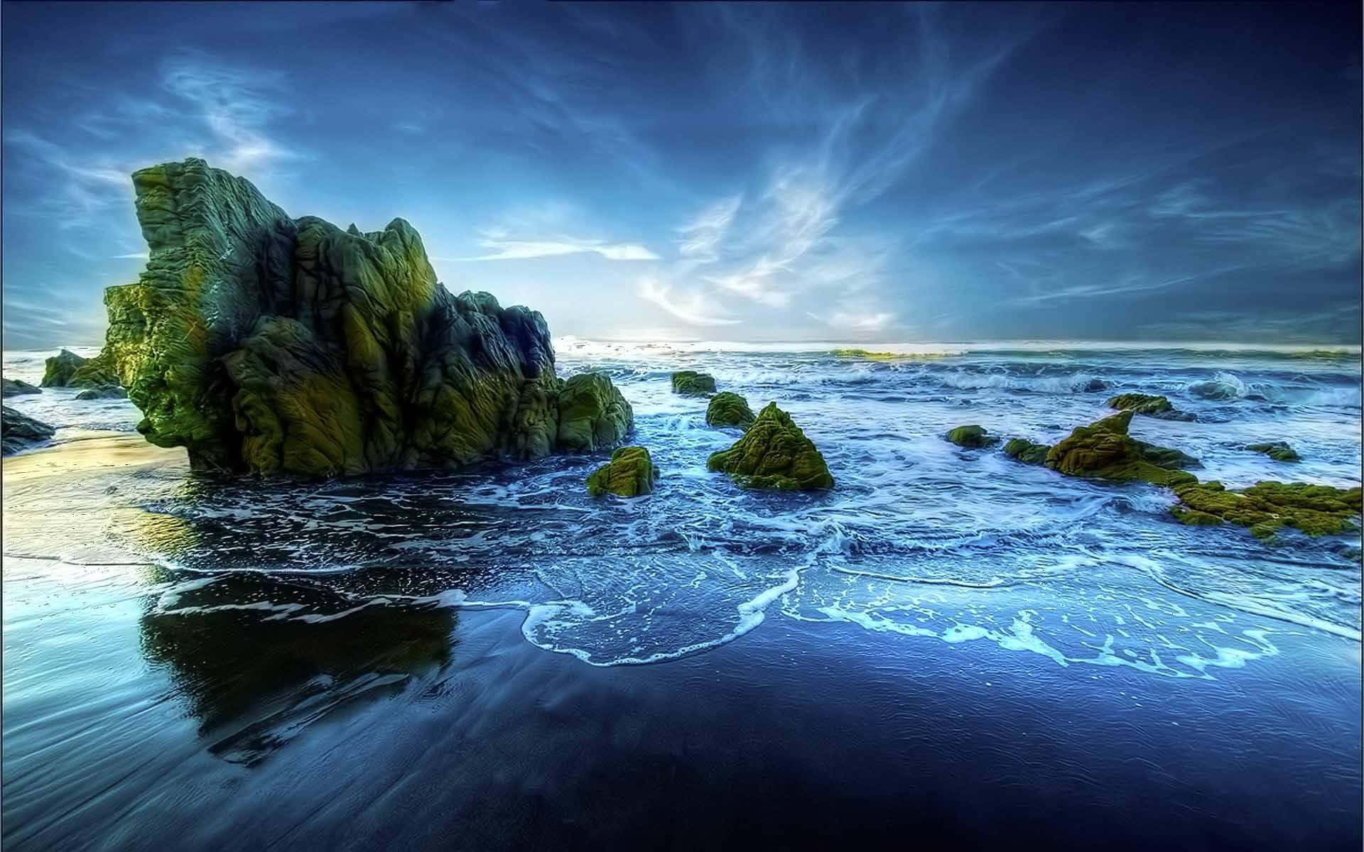 rocky 桌布 壁紙 — 戲劇性的海岸場景，高聳的長滿苔蘚的岩石從深藍色的海浪中突出，在暴風雨的黃昏天空下。