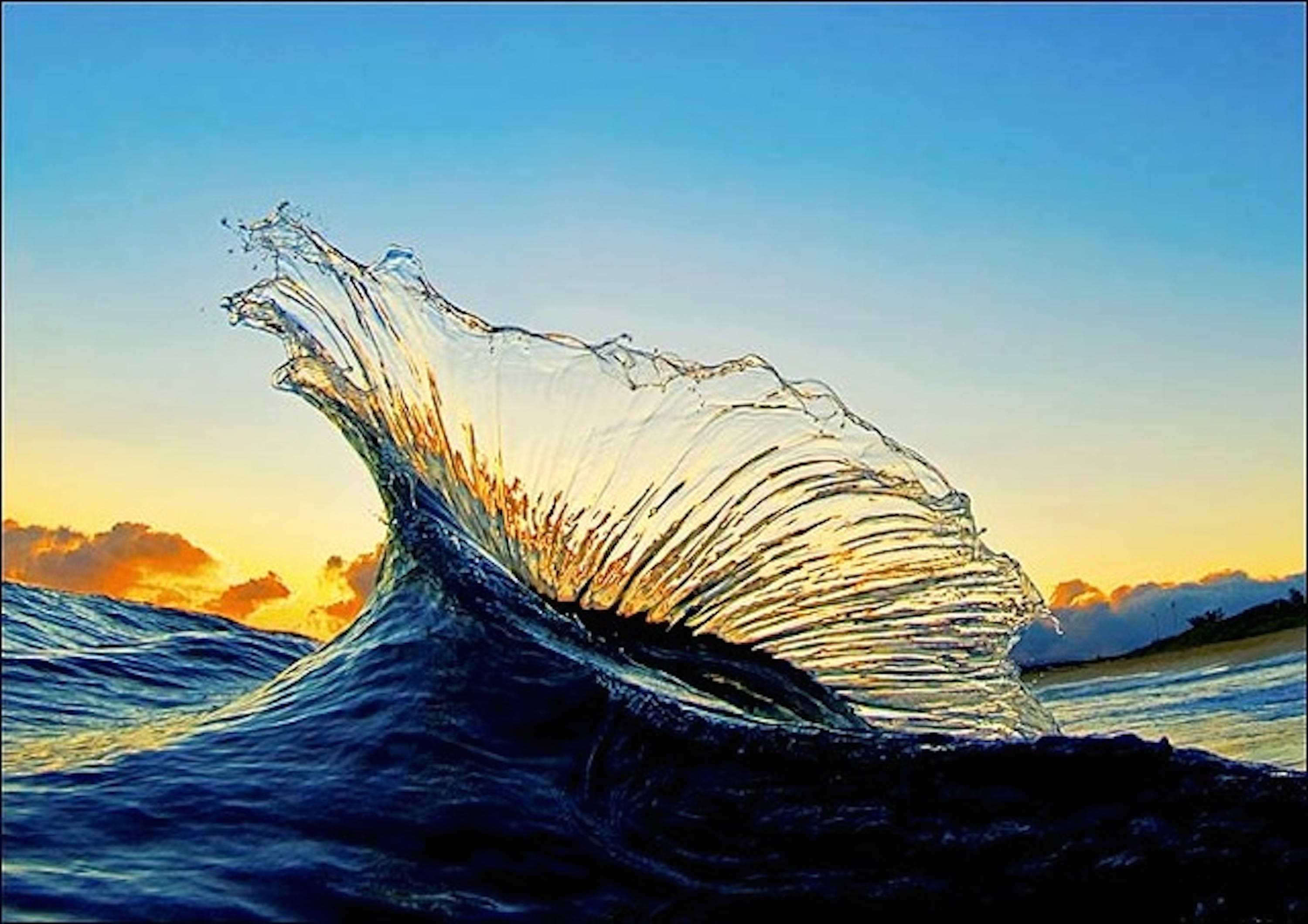 Wave 桌布 壁紙 — 戲劇性的海浪在日落時向上捲起，金色光線穿透其半透明的浪尖，映襯著漸層的天空。