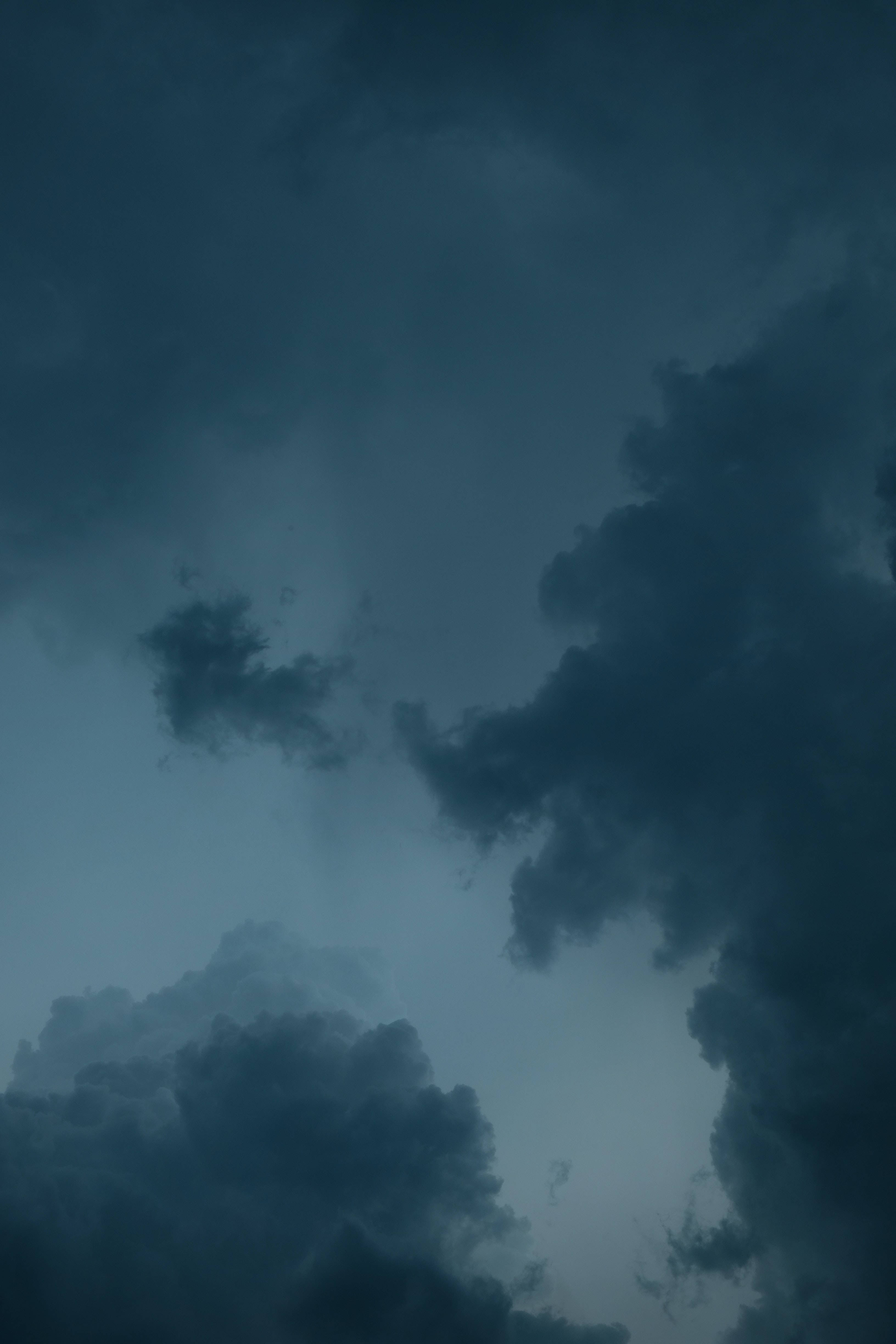 夜空 桌布 壁紙 — 戲劇性的深色暴風雲在充滿氛圍的暮色天空中旋轉，帶有深藍綠色和灰色調。